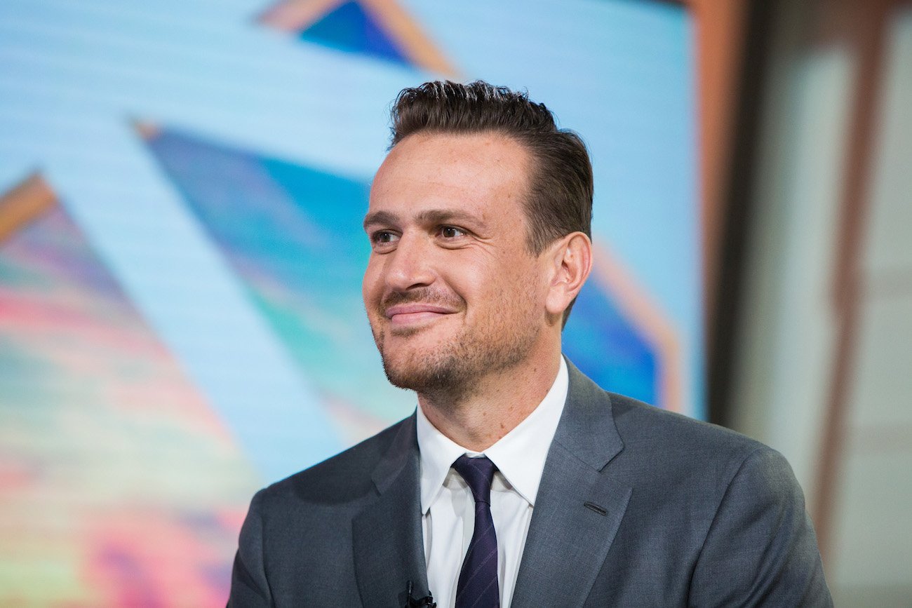 Jason Segel looking on while wearing a suit