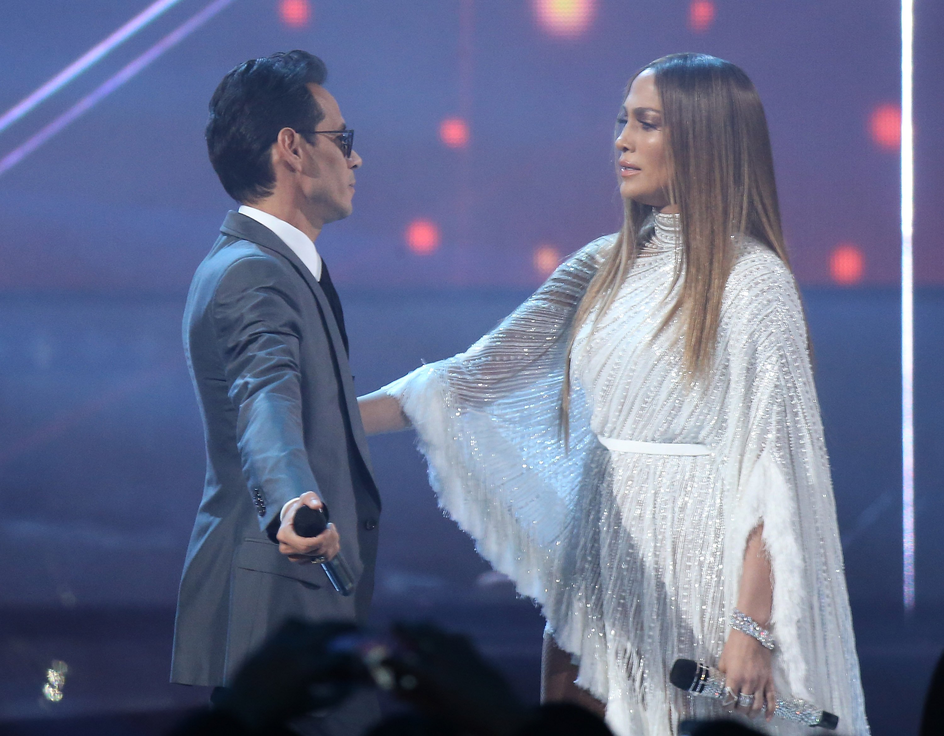 Jennifer Lopez and Marc Anthony sing during a concert.