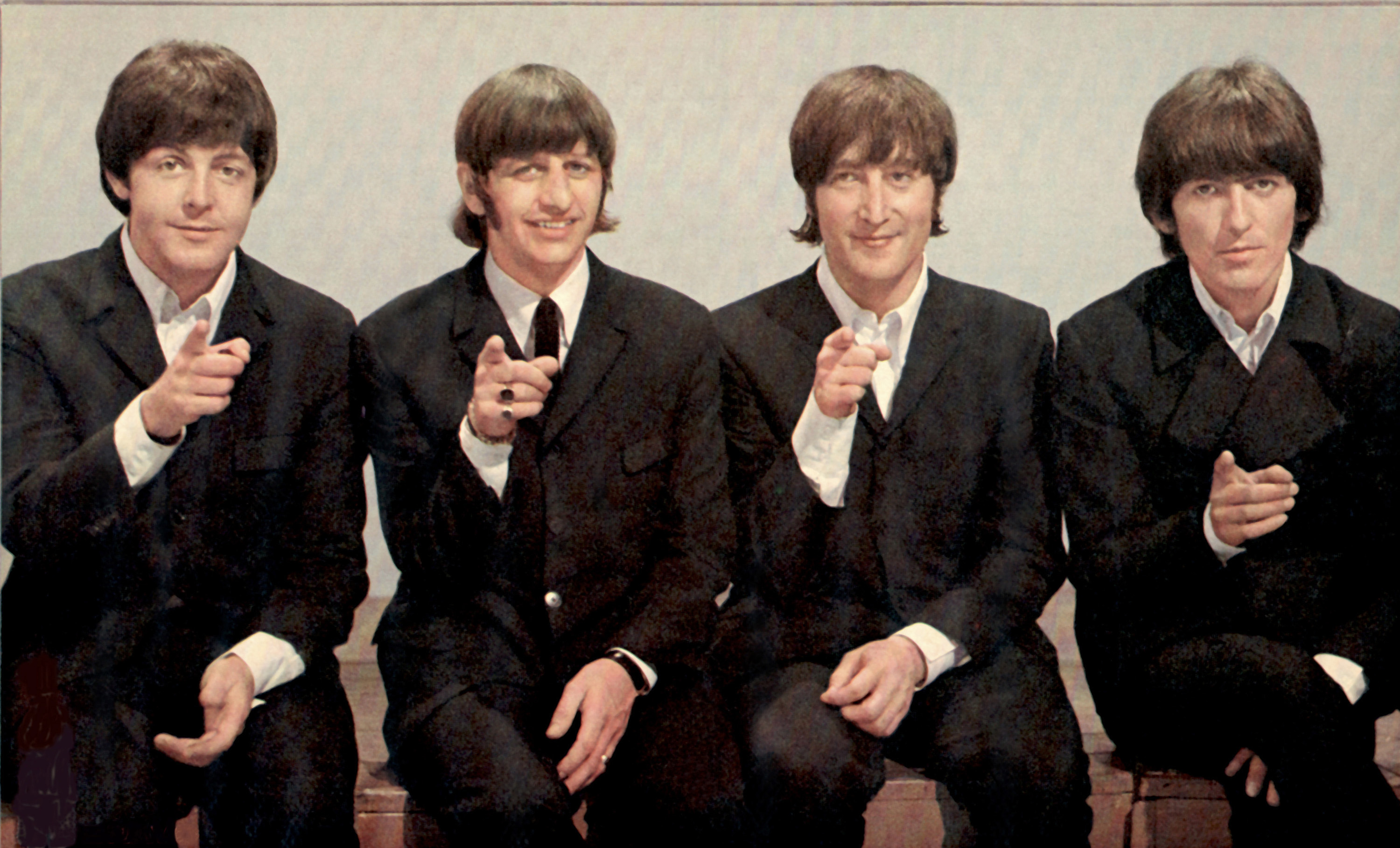 The Beatles' Paul McCartney, Ringo Starr, John Lennon, and George Harrison pointing