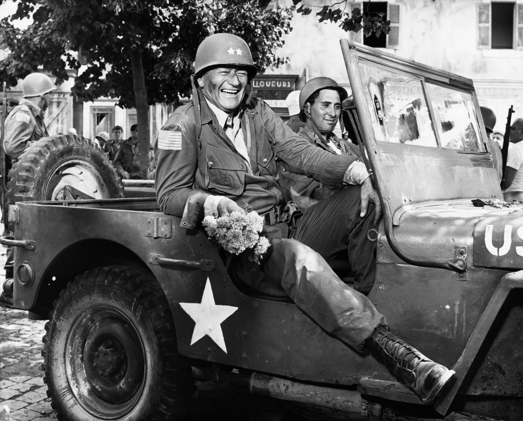 John Wayne as General Mike Randolph in 'Cast a Giant Shadow,' which would be used for the Coors Light commercial riding in a military vehicle smiling
