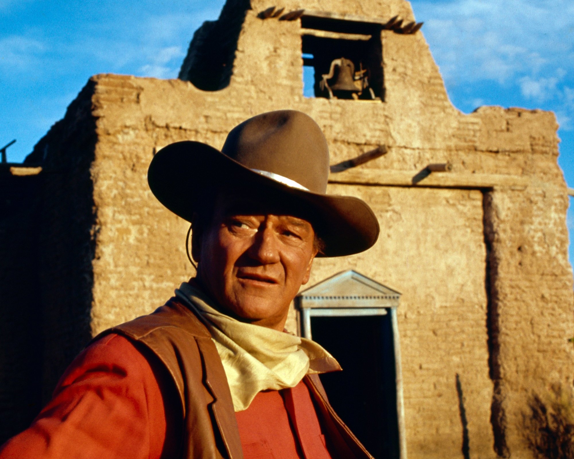 John Wayne movie 'El Dorado' in front of building with a bell wearing cowboy clothes