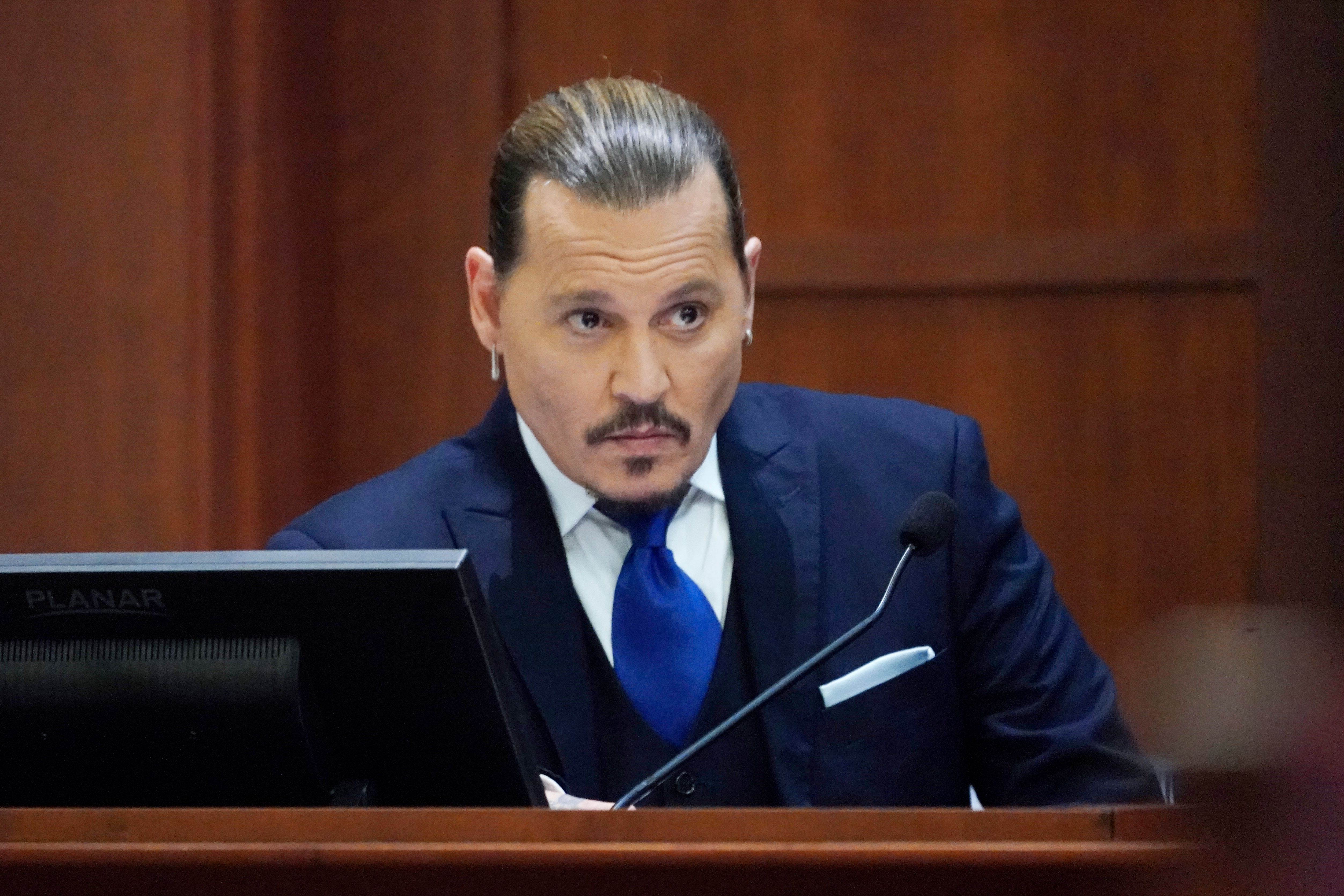 Johnny Depp sits to testify in a defamation case against his ex-wife Amber Heard