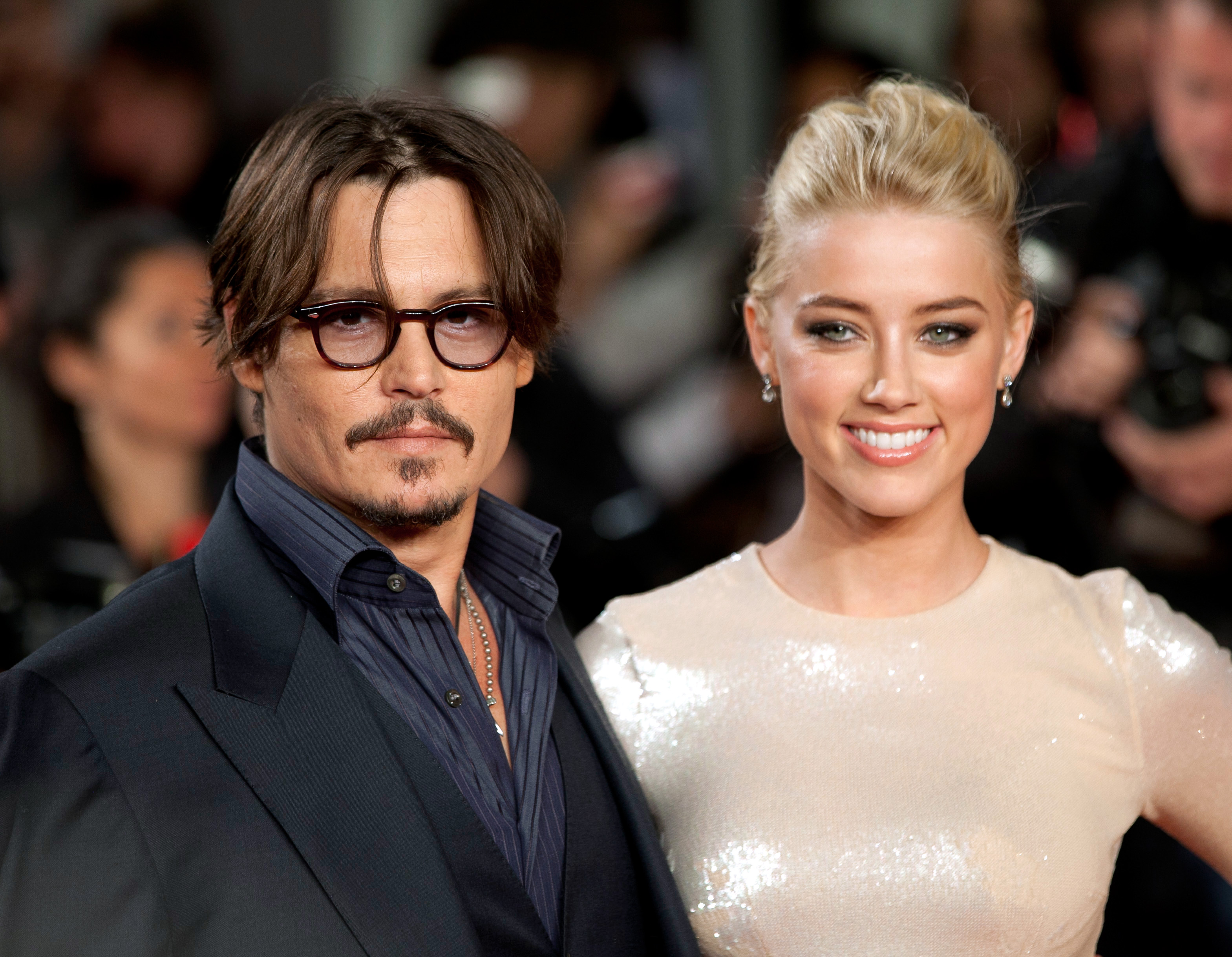Johnny Depp and Amber Heard, who lived in Los Angeles penthouse when they were married, pose together on the carpet at the European premiere of 'The Rum Diary'