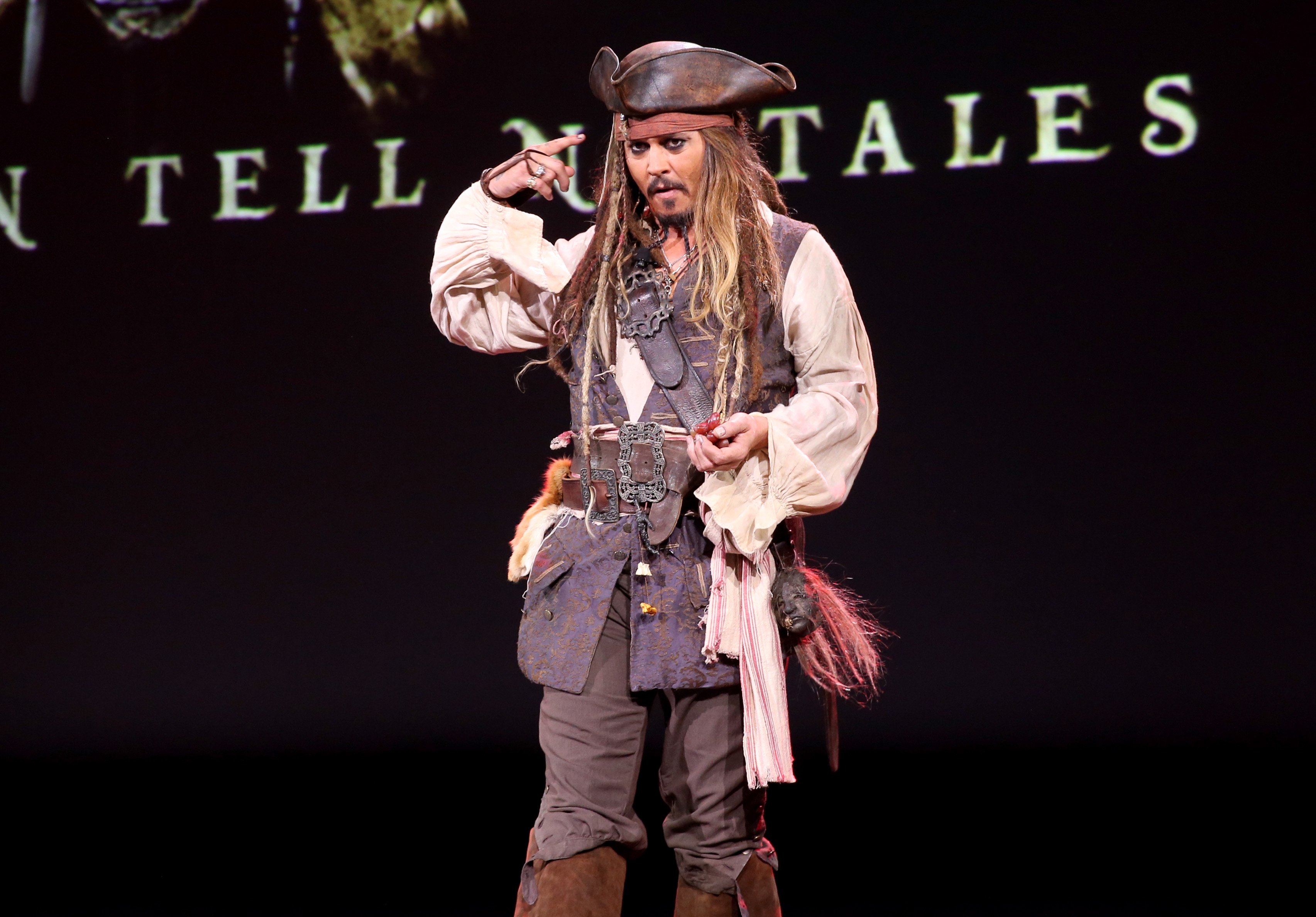 Johnny Depp is dressed as Jack Sparrow while onstage at the 2015 D23 EXPO for Pirates of the Caribbean: Dead Men Tell No Tales