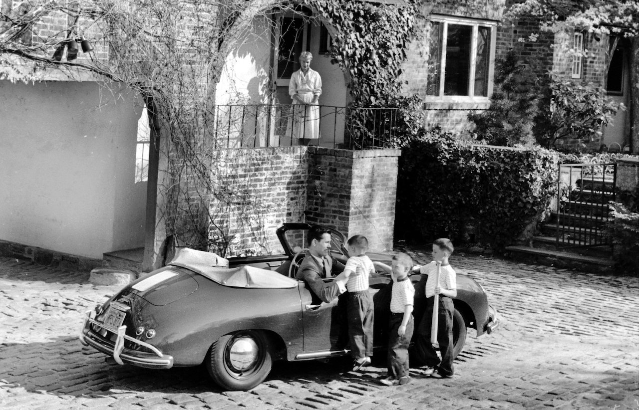 Johnny Carson drives into the rear courtyard of his home, where he is greeted by his sons Cory, Richard, and Christopher. His wife, Jody, waits patiently on the back porch for a "hello" kiss.