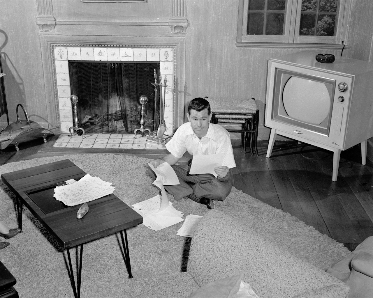 Johnny Carson sits at home in his den reading over a script c. 1958