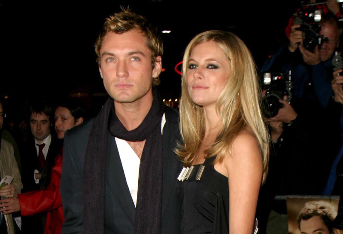 Jude Law and Sienna Miller, who dated before a cheating scandal ended their relationship, pose for photographers while walking the red carpet