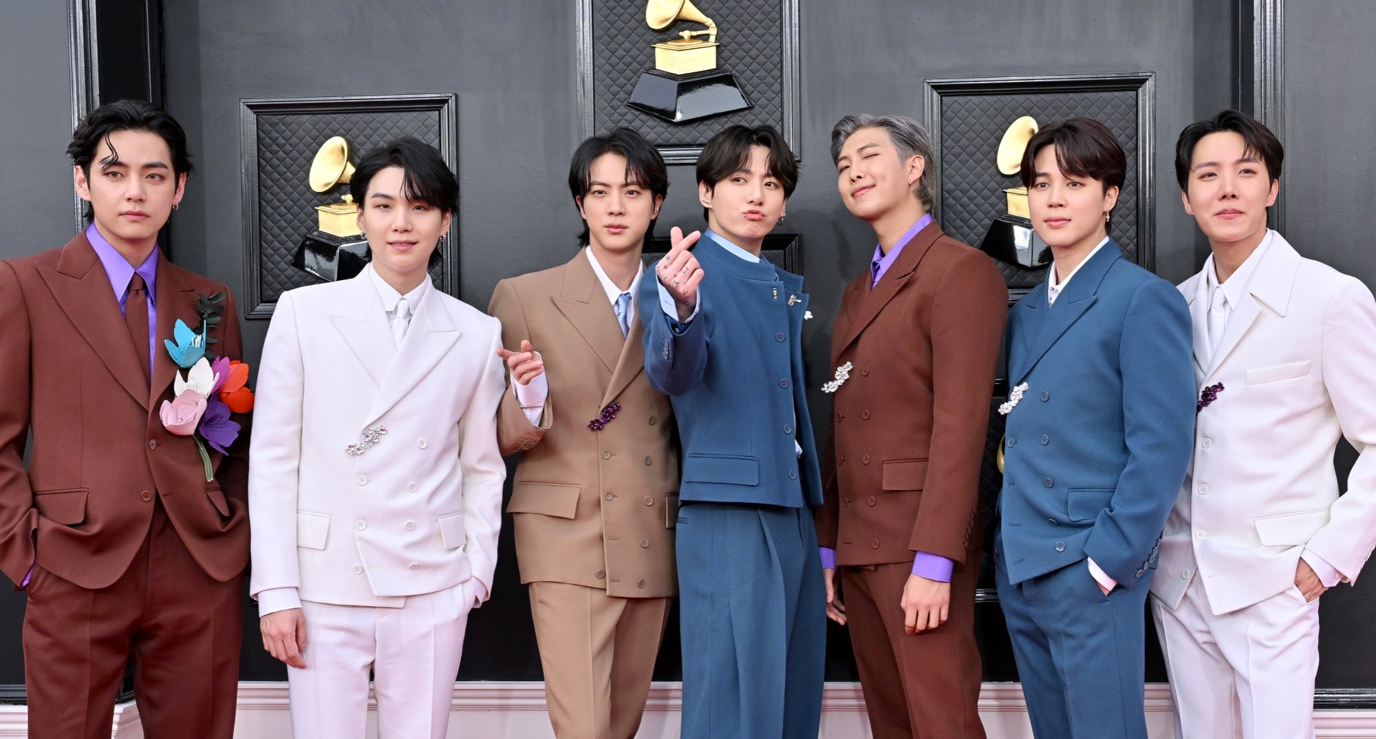 K-drama fans BTS wearing suits and posing on the red carpet at the 2022 Grammy Awards.
