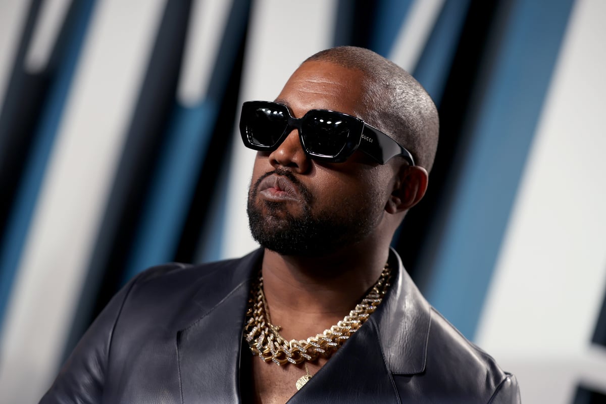Wearing a black leather suit jacket and sunglasses, Kanye West attends the 2020 Vanity Fair Oscar Party