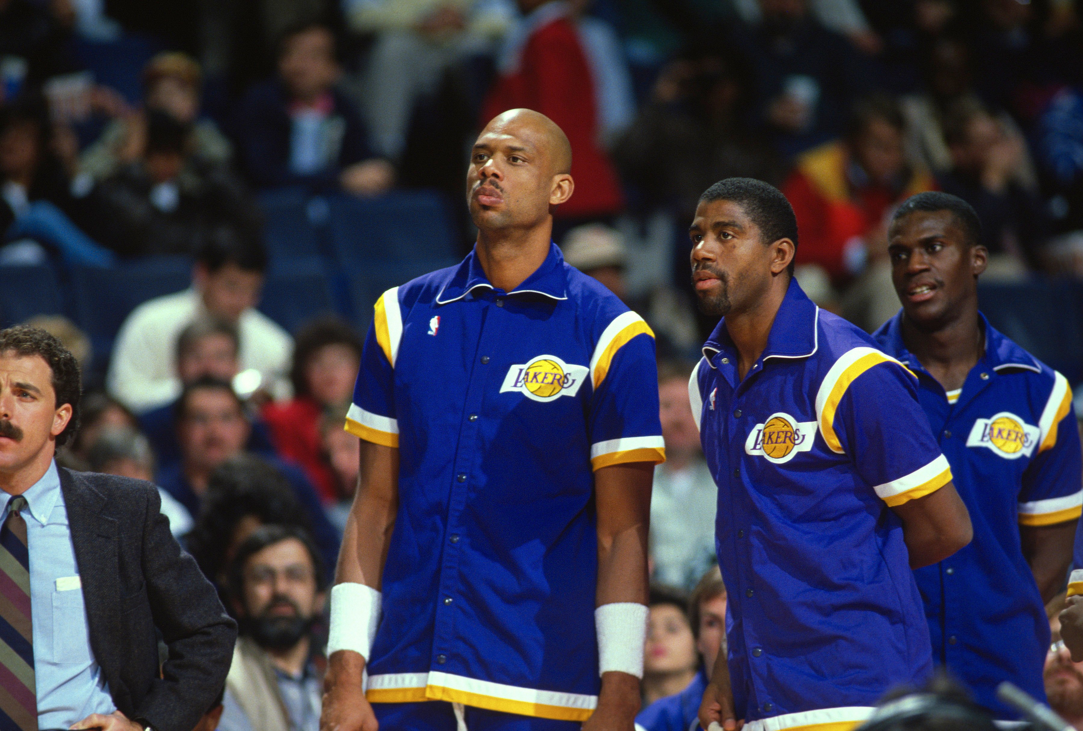 Kareem Abdul-Jabbar, Magic Johnson, and Orlando Woolridge standing next to each other during a 1988 basketball game against Washington Bullets