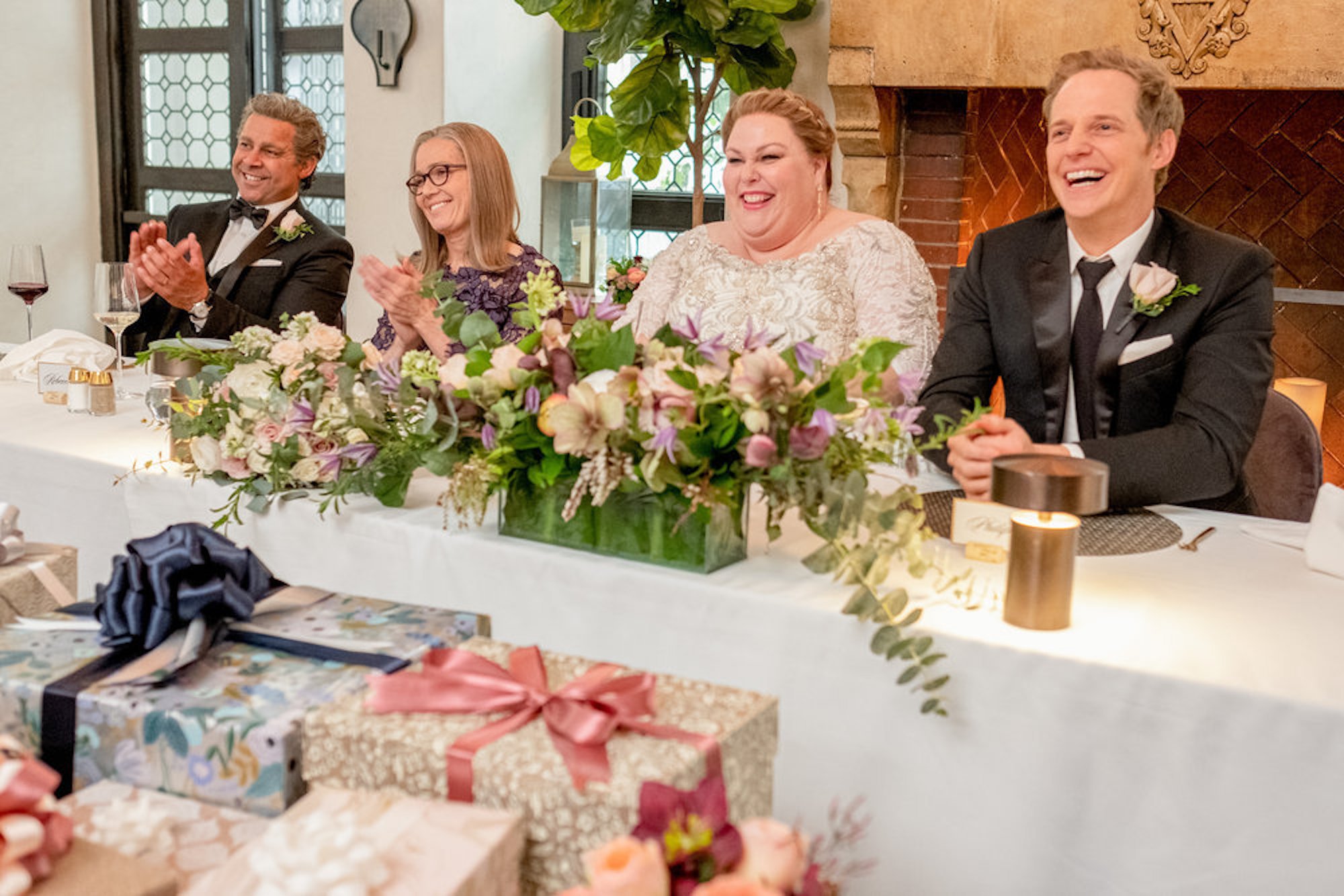 Miguel, Rebecca, Kate, and Phillip sitting at a table at Kate's wedding in 'This Is Us' Season 6 Episode 13