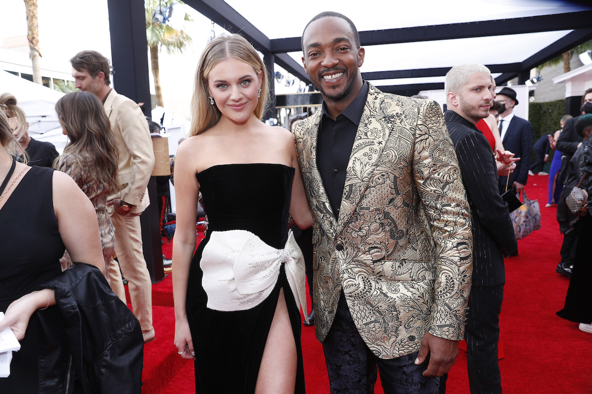 Kelsea Ballerini and Anthony Mackie pose together at an event.