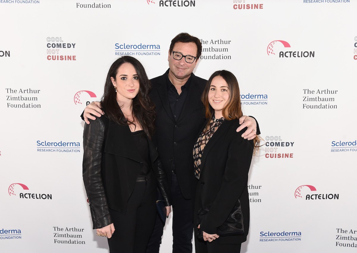 Lara Saget, Bob Saget, and Aubrey Saget smile and pose together at an event.