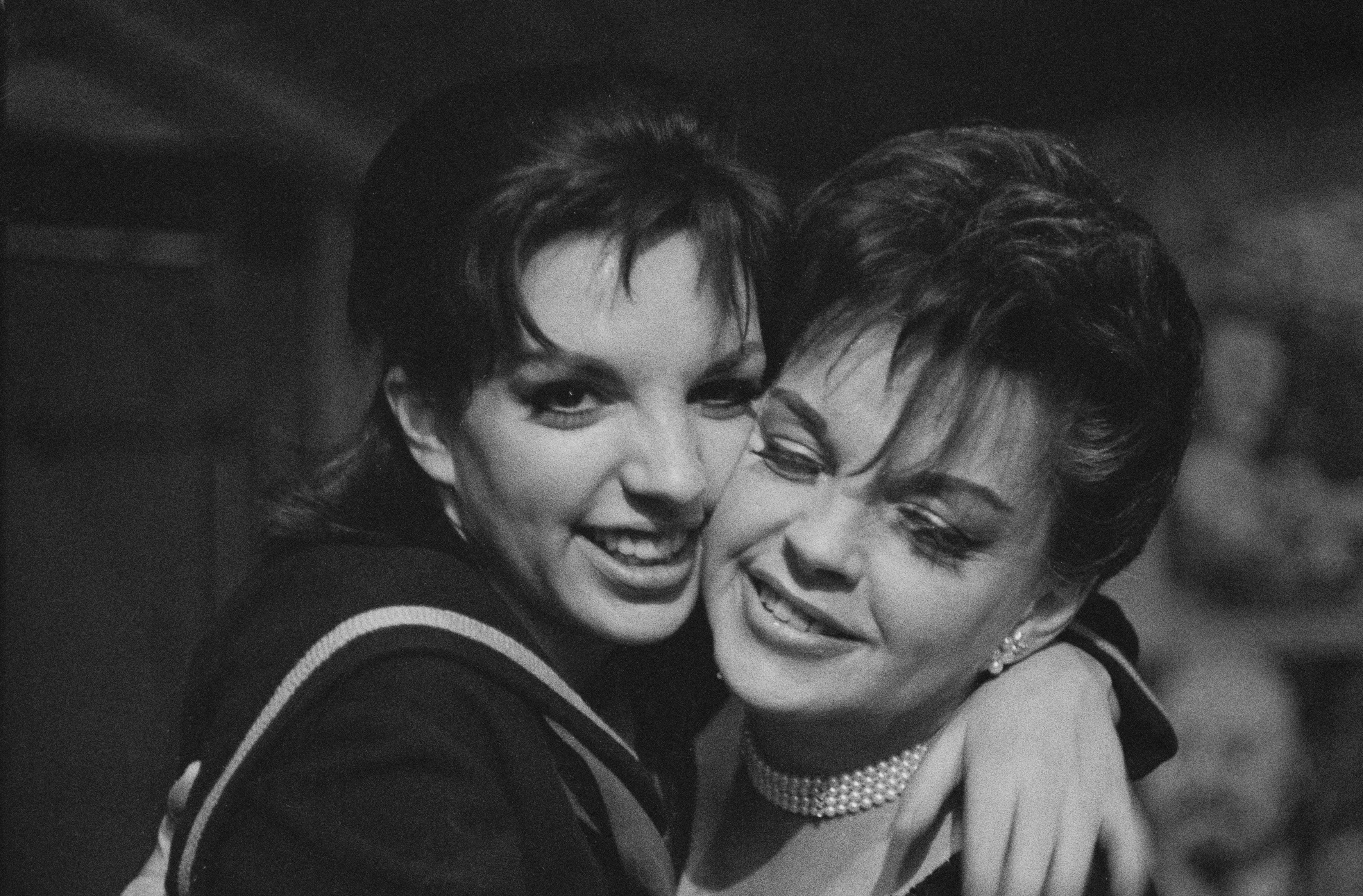 A black and white photo of Liza Minnelli and Judy Garland hugging each other.