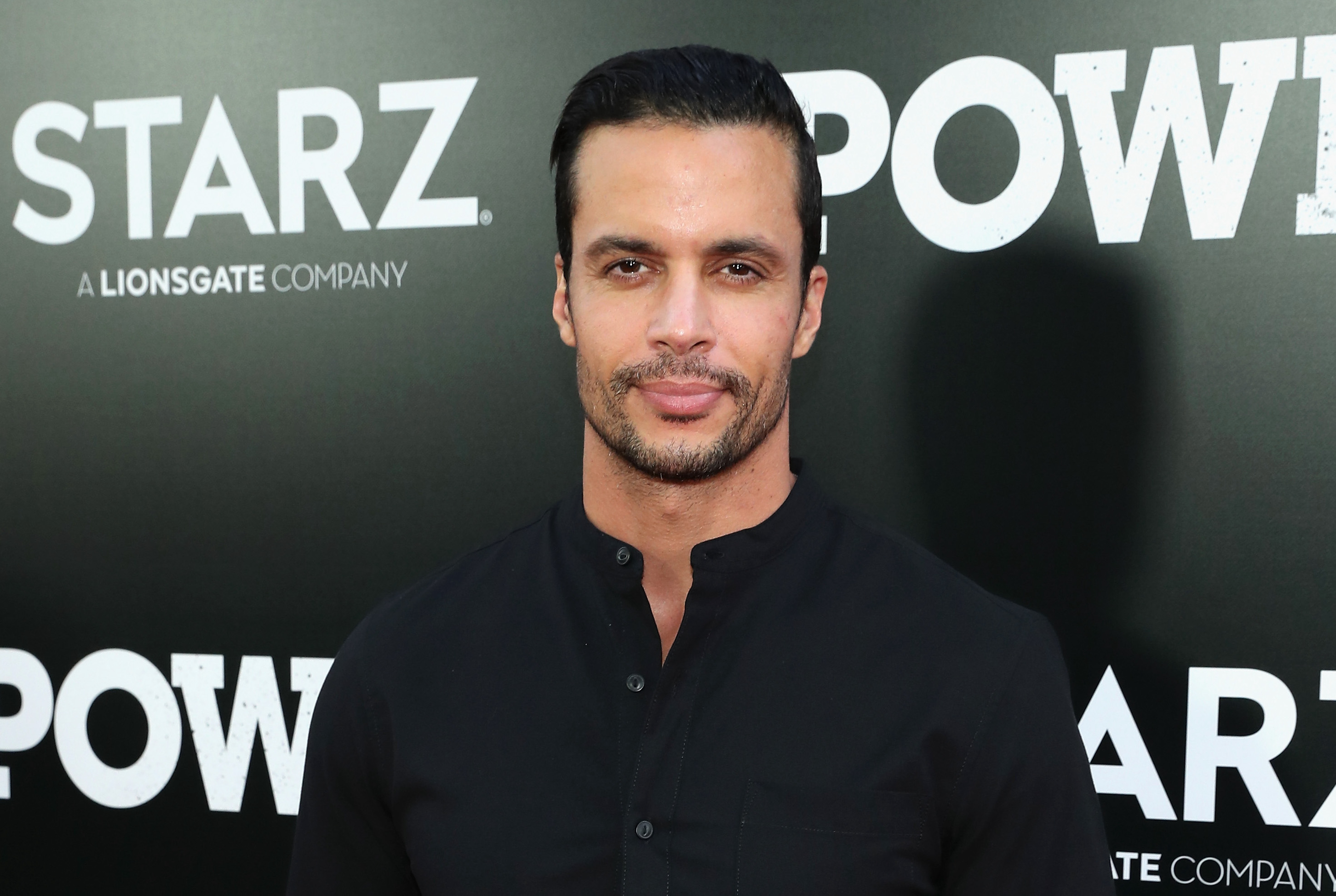Matthew Cedeño, who is rumored to reprise his role as Cristobal in 'Power Book II: Ghost,' poses on the red carpet wearing a black shirt with his hair slicked back