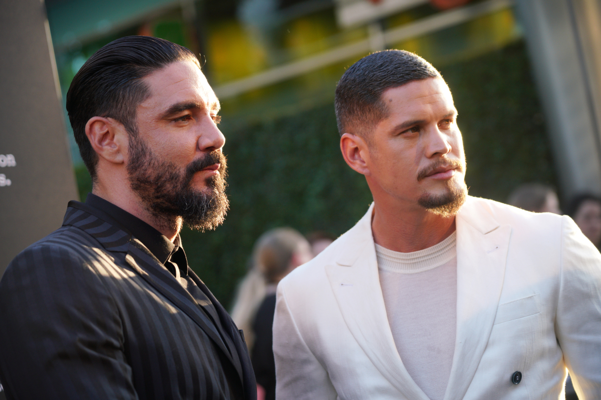 Mayans MC Season 4 actors Clayton Cardenas and J. D. Pardo. Cardenas wears a black suit and Pardo wears a white one. 