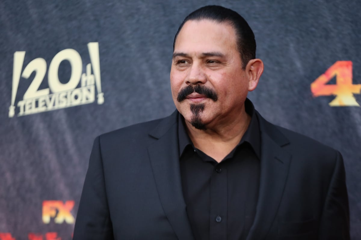 Emilio Rivera who plays Alvarez in Mayans MC Season 4. Rivera wears a black shirt and suit jacket.