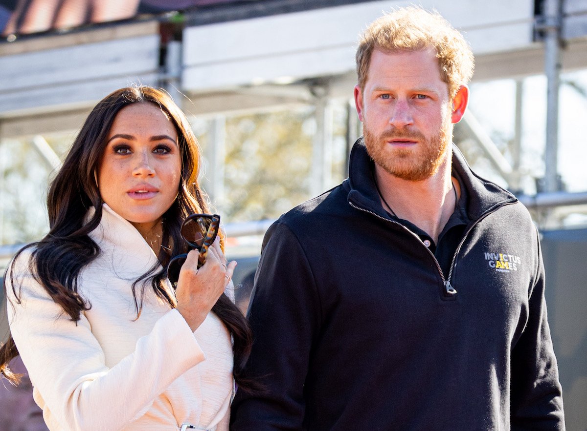 Meghan Markle and Prince Harry look on wearing white and black