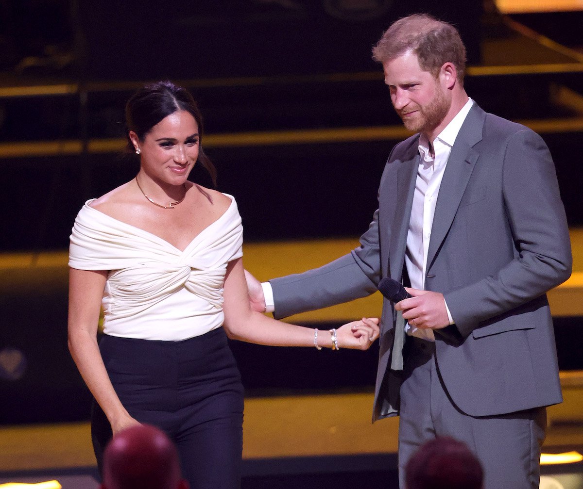 Meghan Markle stands next to Prince Harry as she introduces him at the 2022 Invictus Games