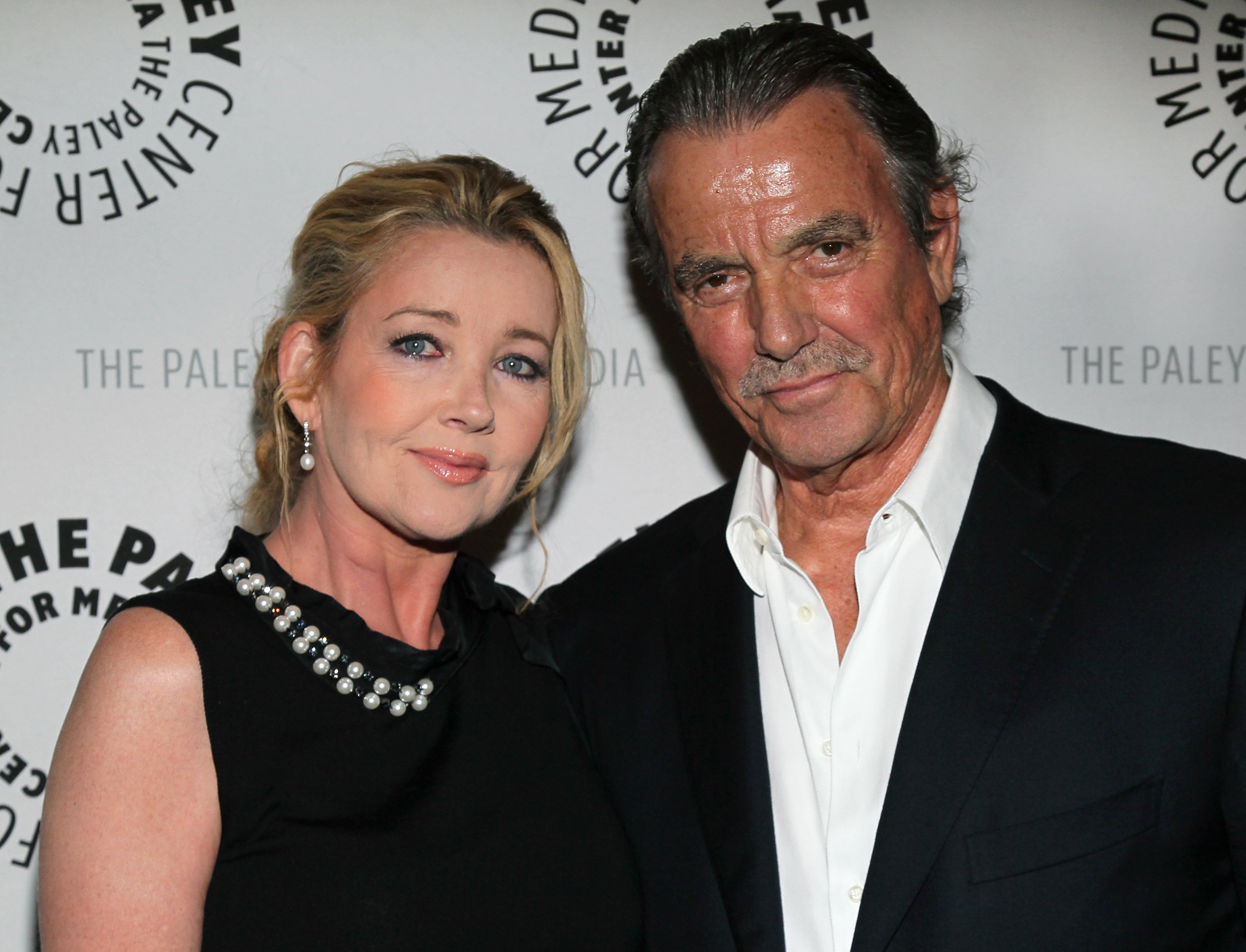 'The Young and the Restless' actor Melody Thomas Scott in a black dress, and Eric Braeden in a black suit and white shirt attend a red carpet event.