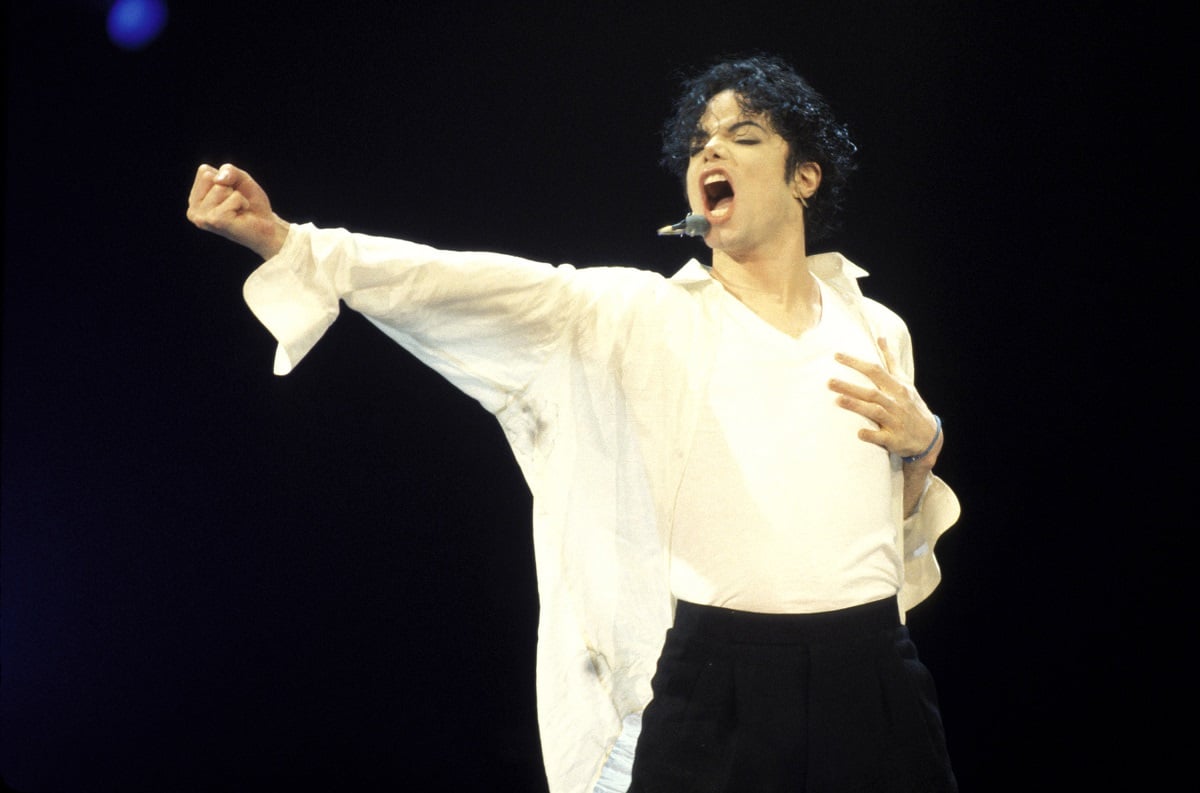 Michael Jackson singing while wearing a white shirt.
