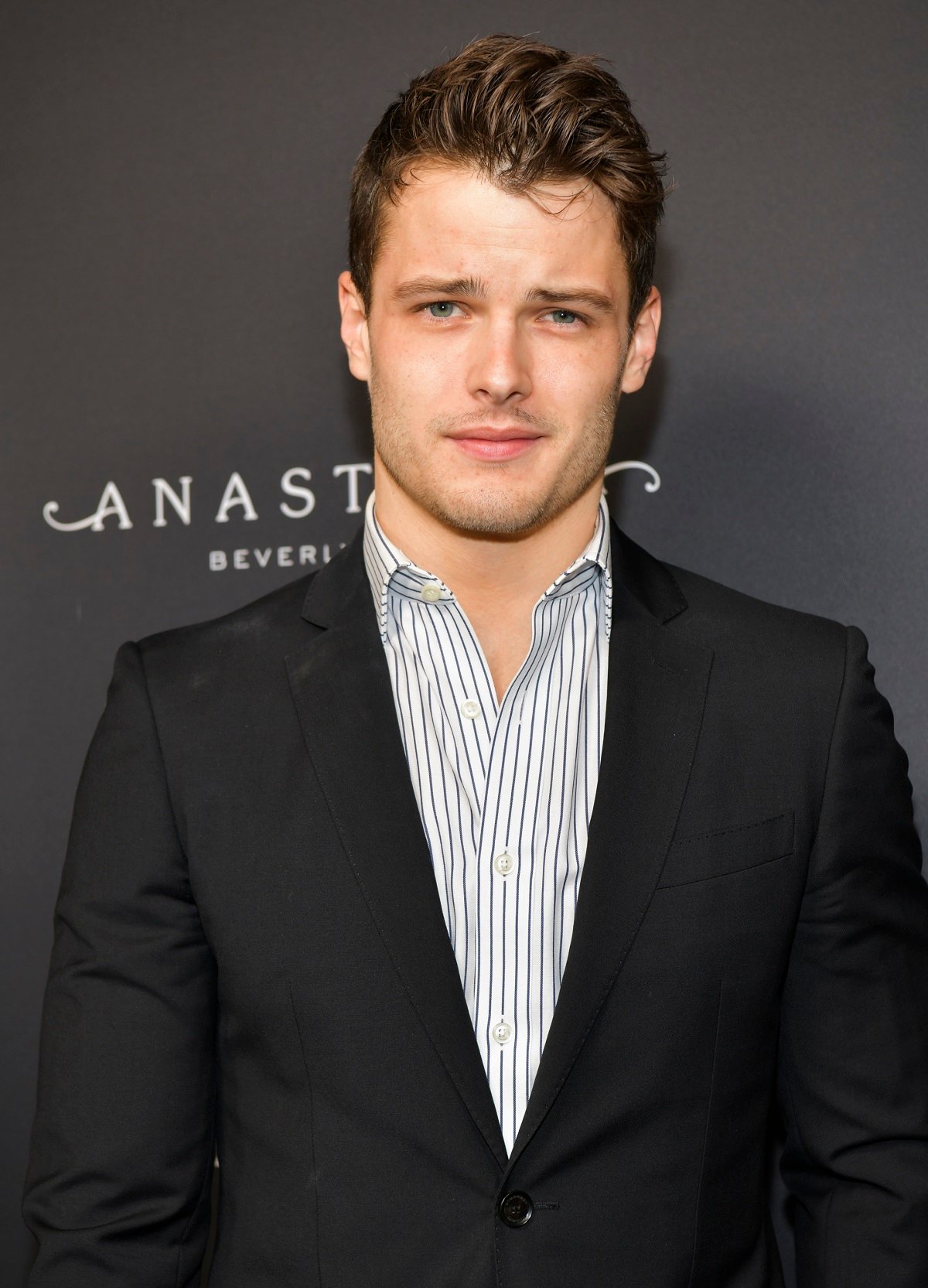 'The Young and the Restless' actor Michael Mealor wearing a black suit and blue and white striped shirt.