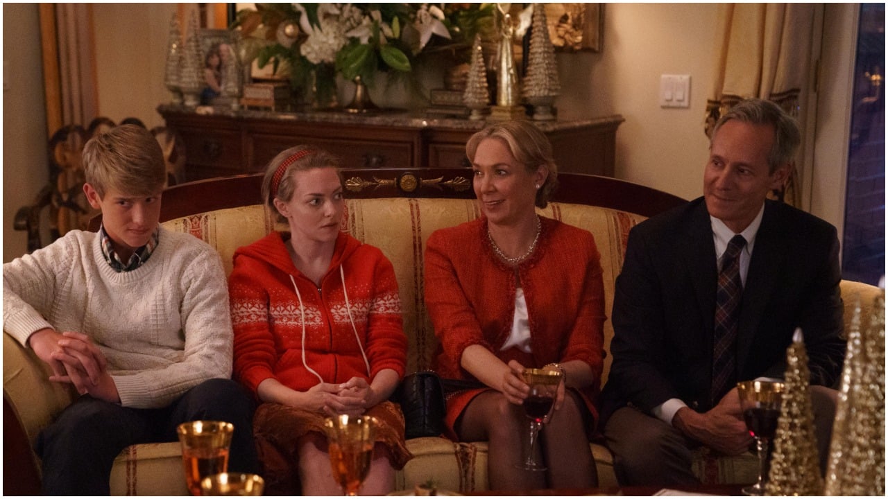 Michel Gill as Chris Holmes, Amanda Seyfried as Elizabeth Holmes, Elizabeth Marvel as Noel Holmes, and Sam Straley as Christian Holmes sitting on a couch during an episode of 'The Dropout'