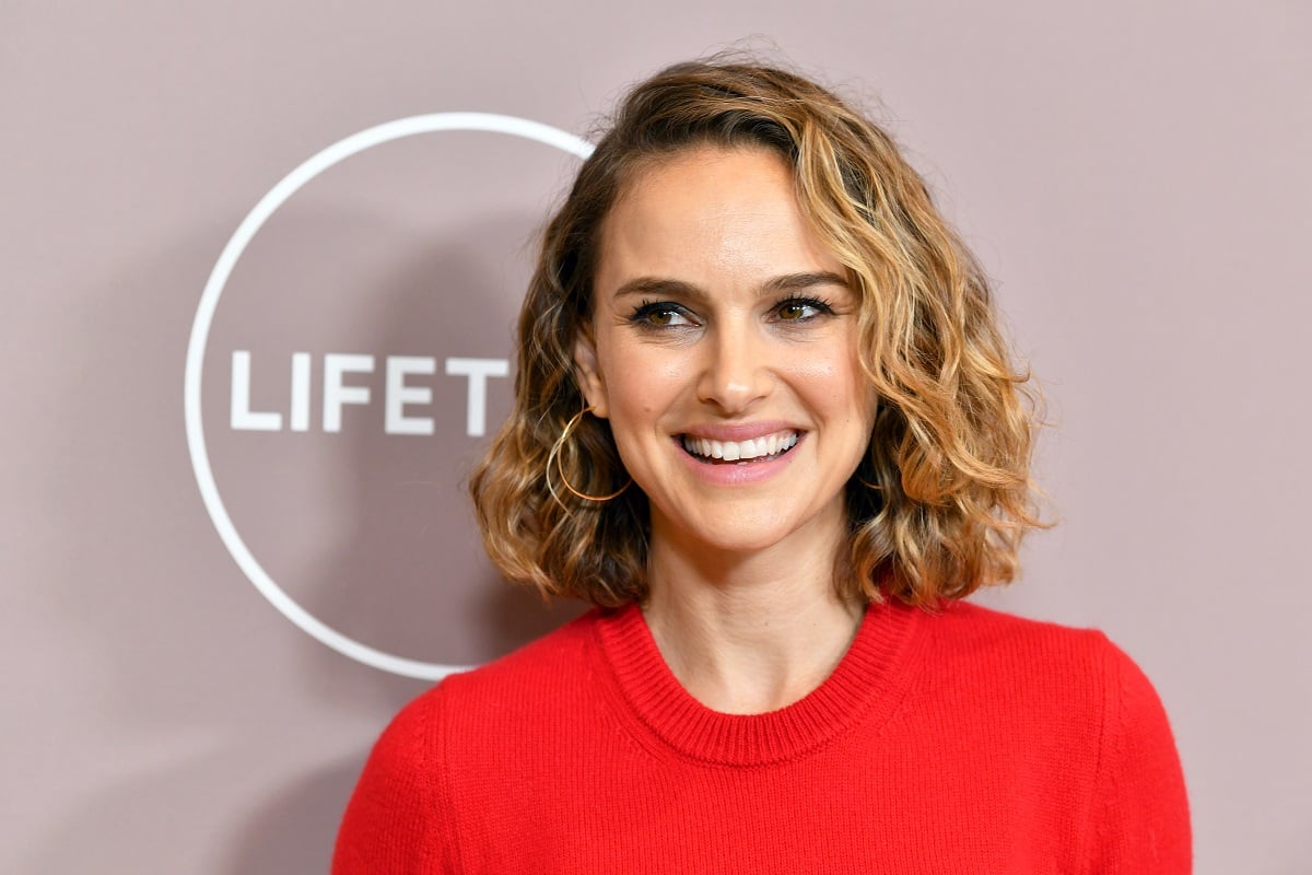 Natalie Portman smiling while wearing a red dress.