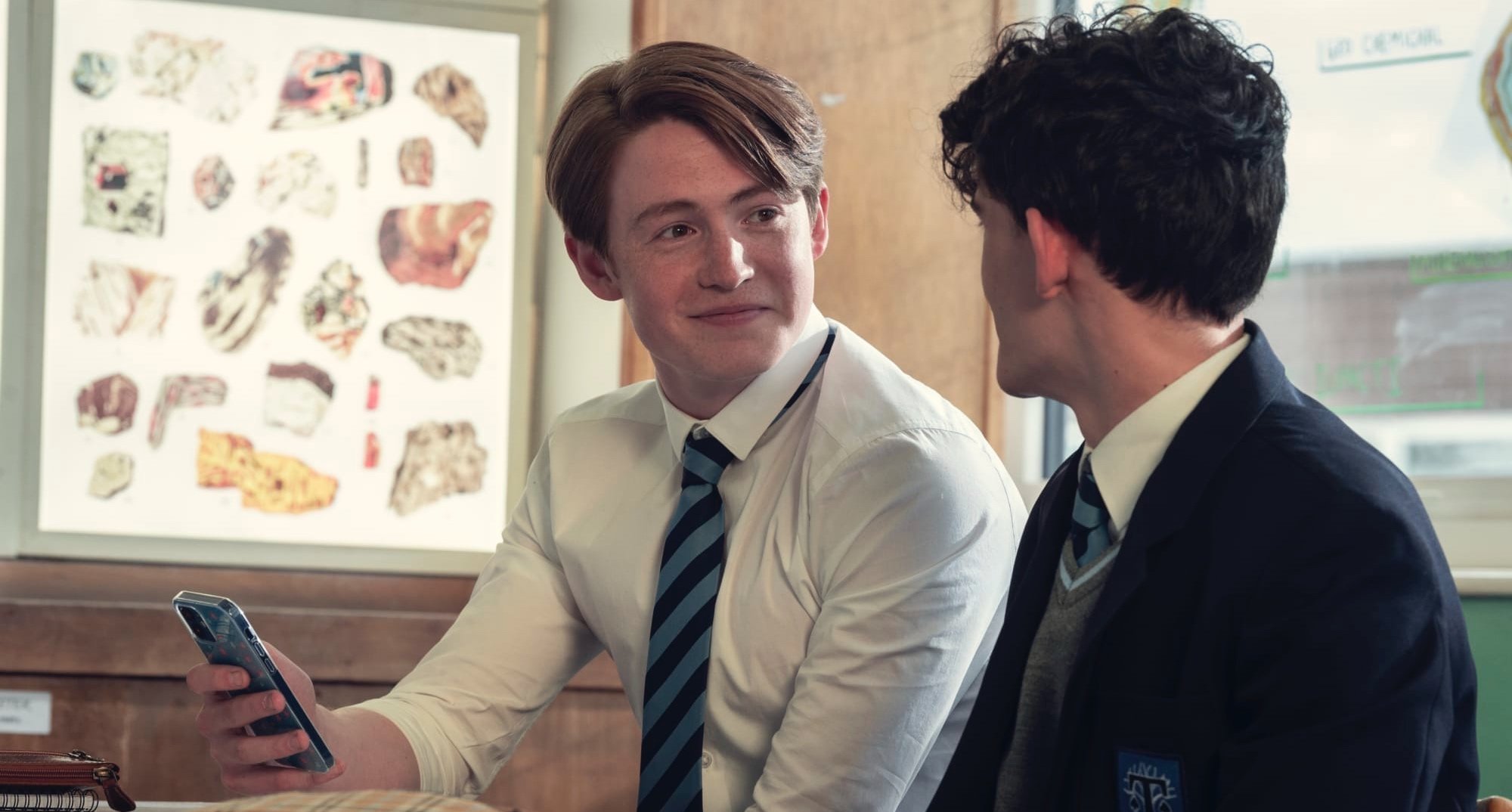 Nick Nelson from 'Heartstopper' series wearing school uniform staring at Charlie.