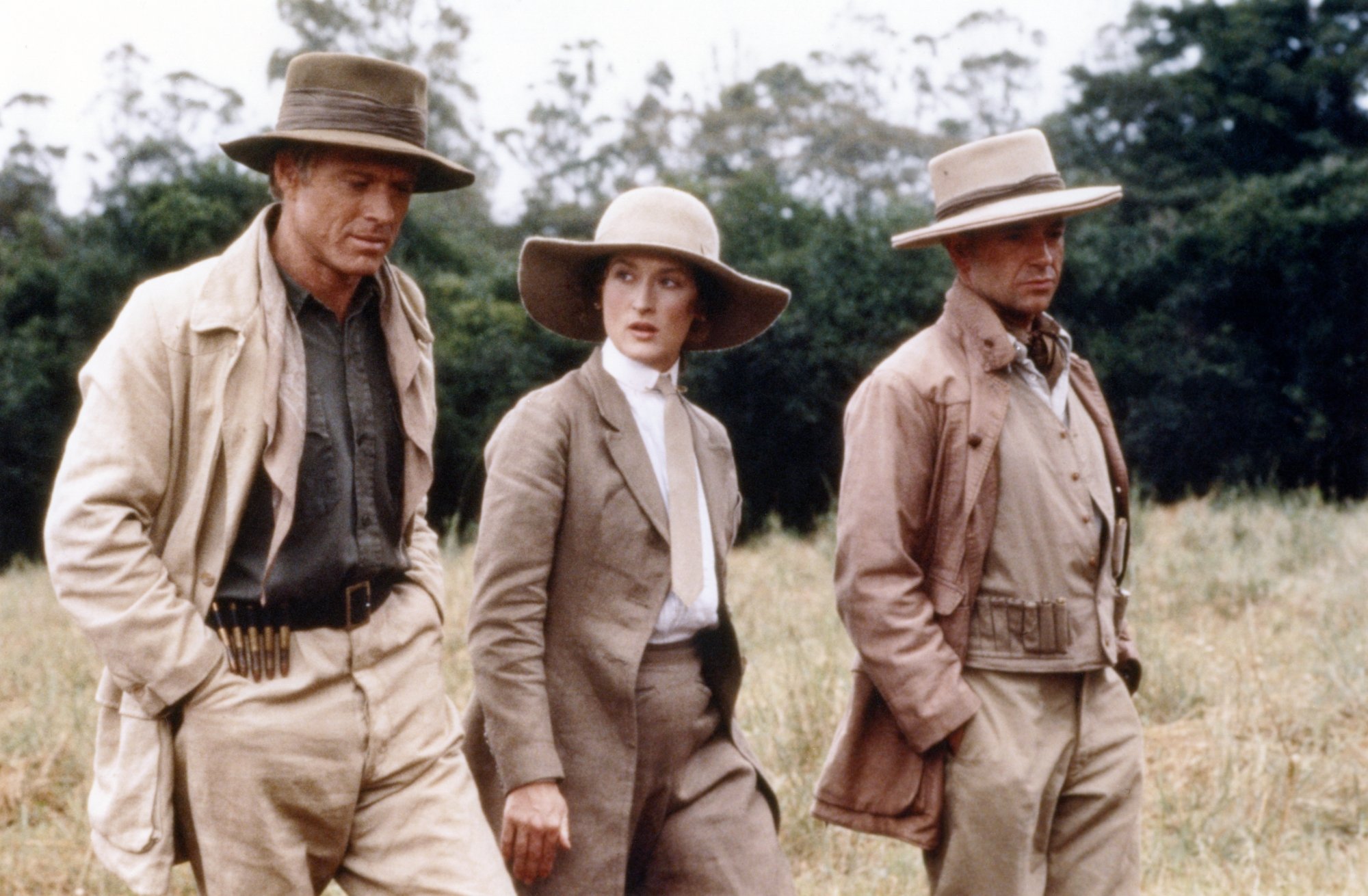 'Out of Africa' Robert Redford as Denys, Meryl Streep as Karen Blixen, and Michael Kitchen walking through a plain in Africa wearing safari clothes