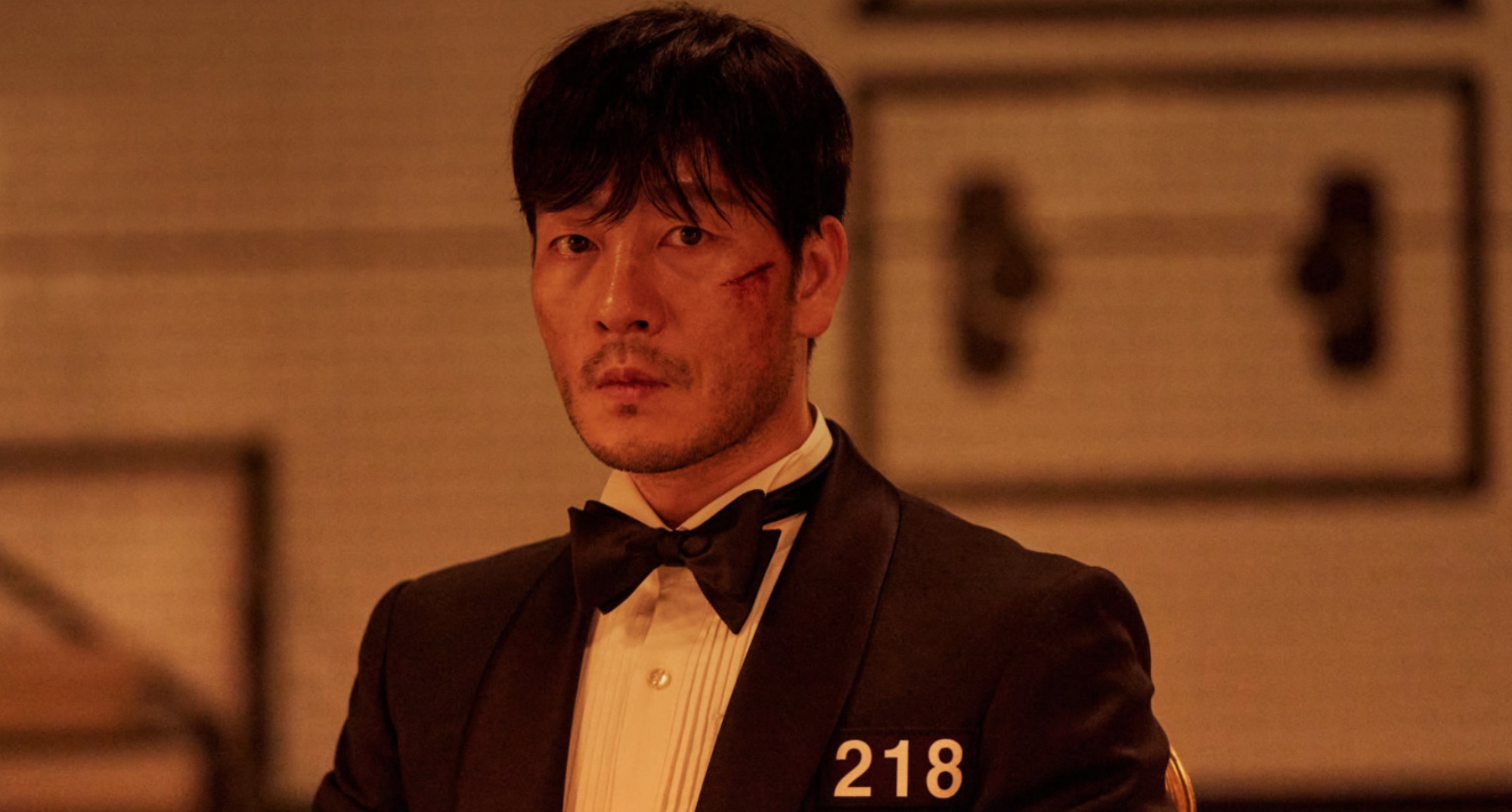 Park Hae-soo as Sang-woo in 'Squid Game' wearing tuxedo and bloody.