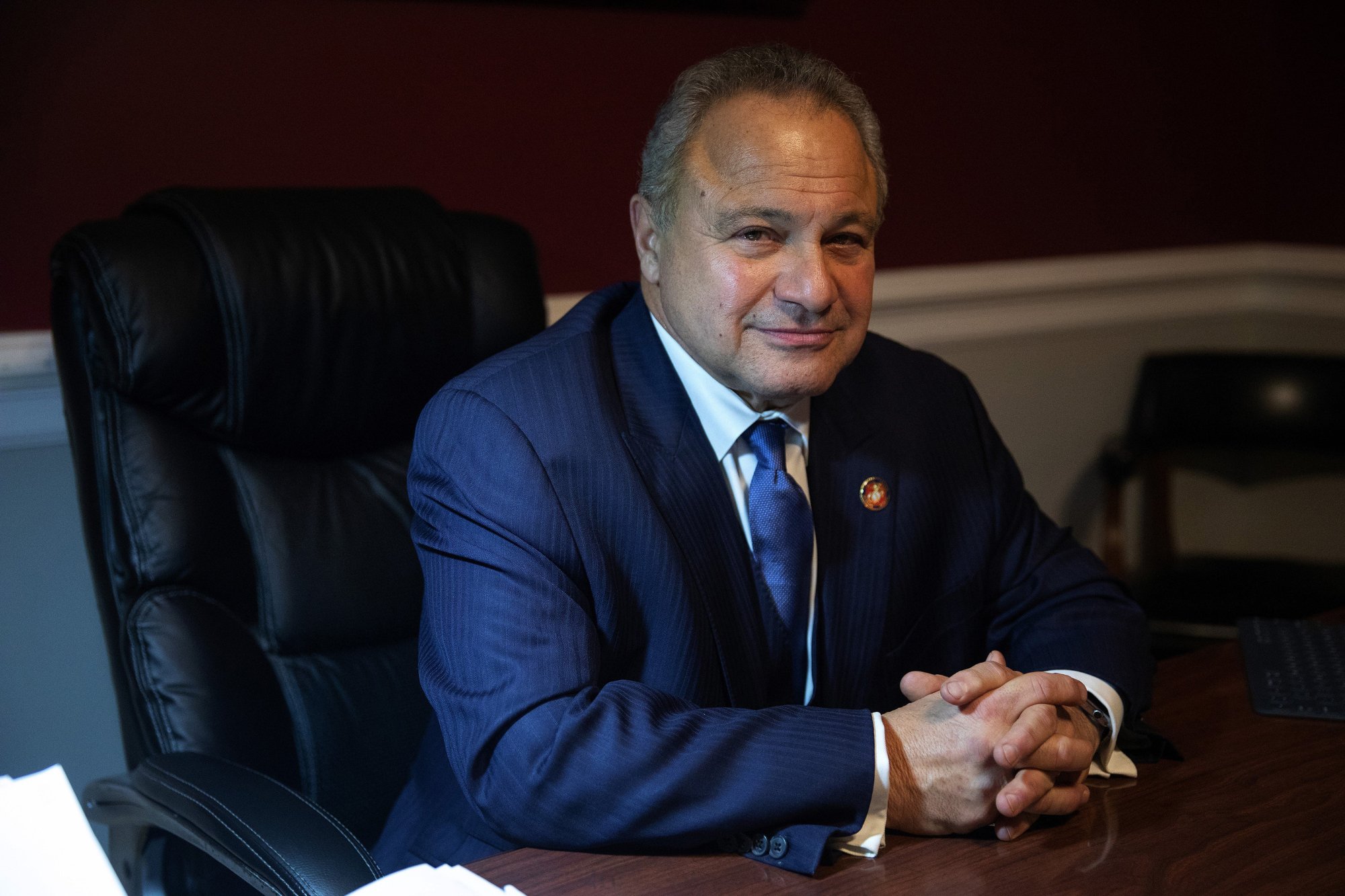 Previous Assistant Public Defender Sam Amirante, who represented John Wayne Gacy sitting behind his desk in a suit with his hands folded