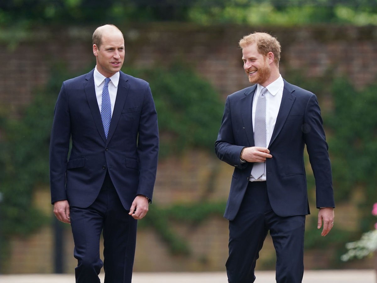 Prince William and Prince Harry smile as they walk next to each other at Kensington Palace