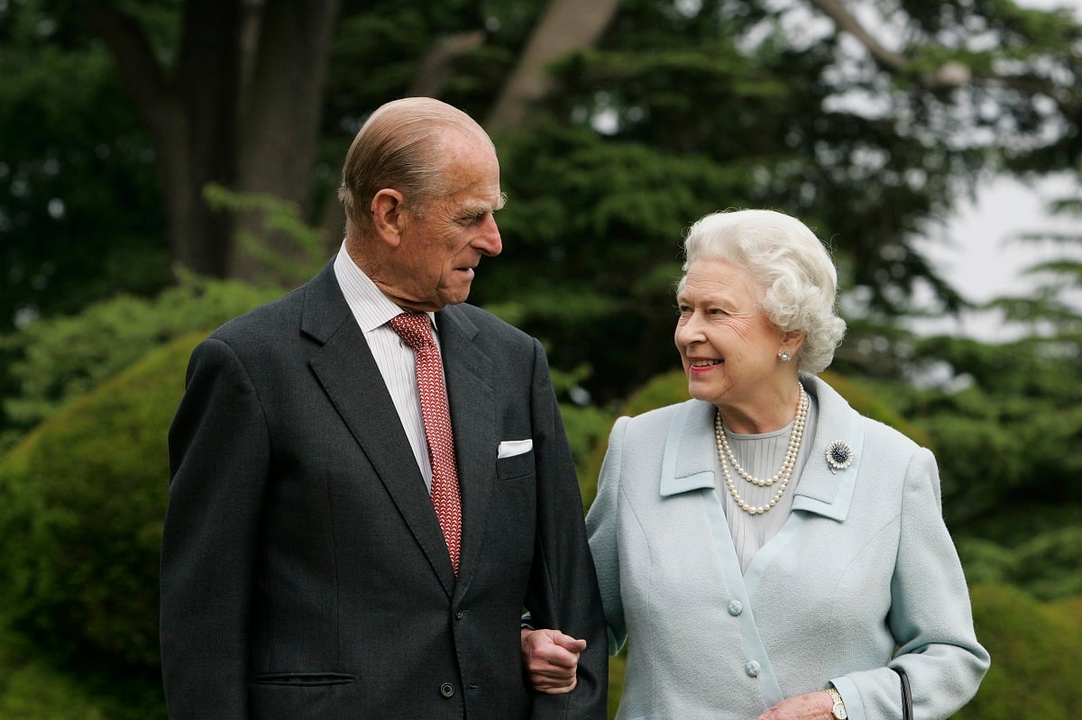 Queen Elizabeth II and Prince Philip pose for a photo walking arm-in-arm marking their Diamond Wedding Anniversary