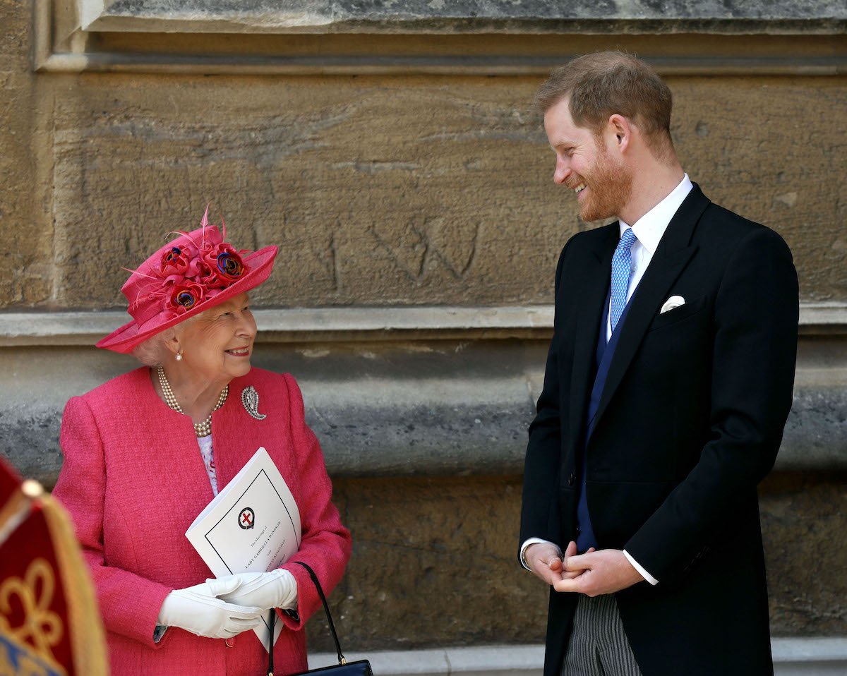 Queen Elizabeth II, who celebrates her platinum jubilee in 2022, smiles at Prince Harry