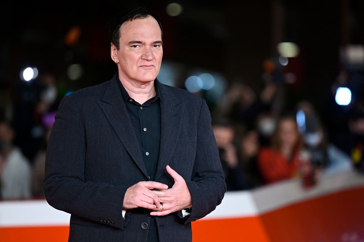 Quentin Tarantino posing while wearing a black suit.