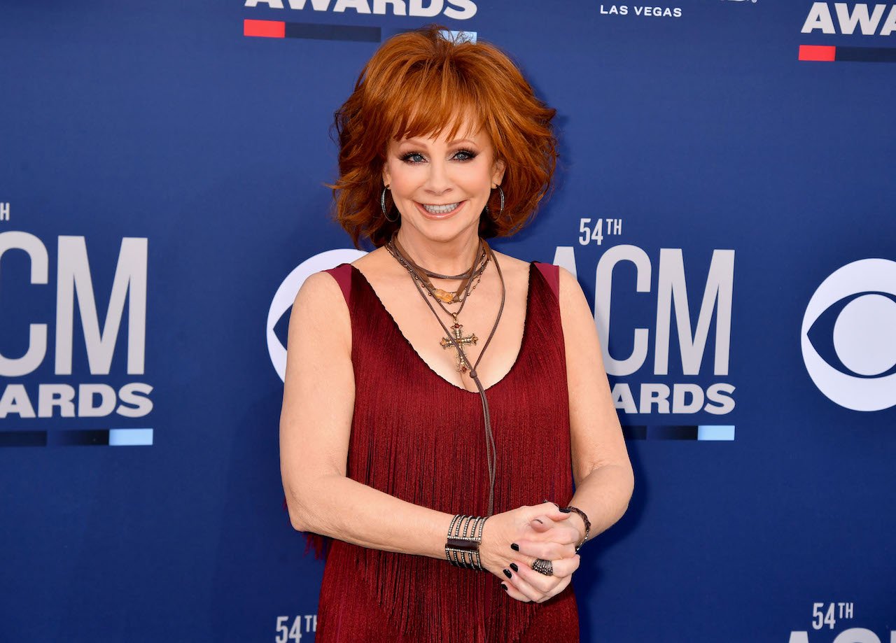 Reba McEntire with her hands together, smiling