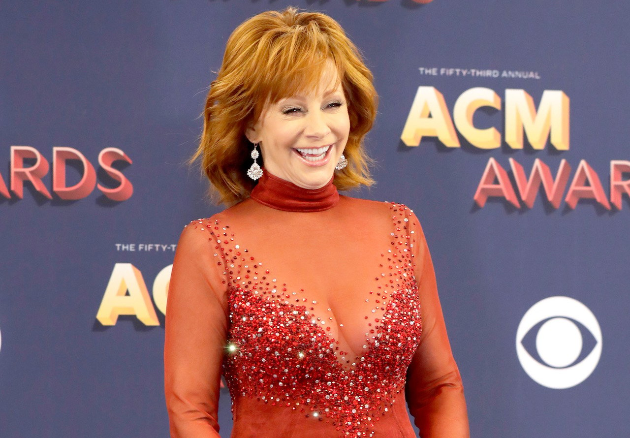 Reba McEntire laughs and poses for a picture in her red dress from the '93 CMA Awards in 2018