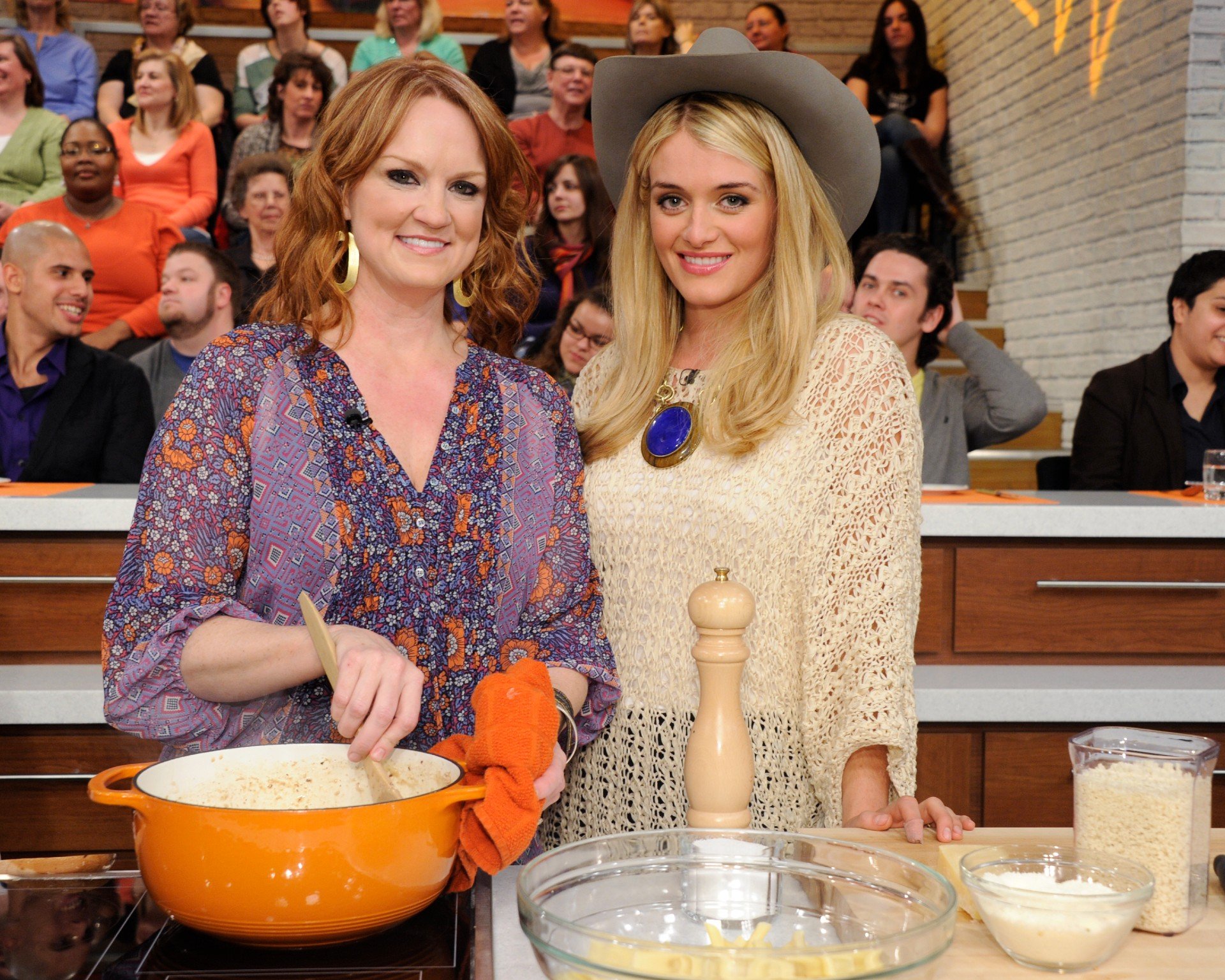 Ree Drummond stirs a pot of food while posing next to Daphne Oz on The Chew.