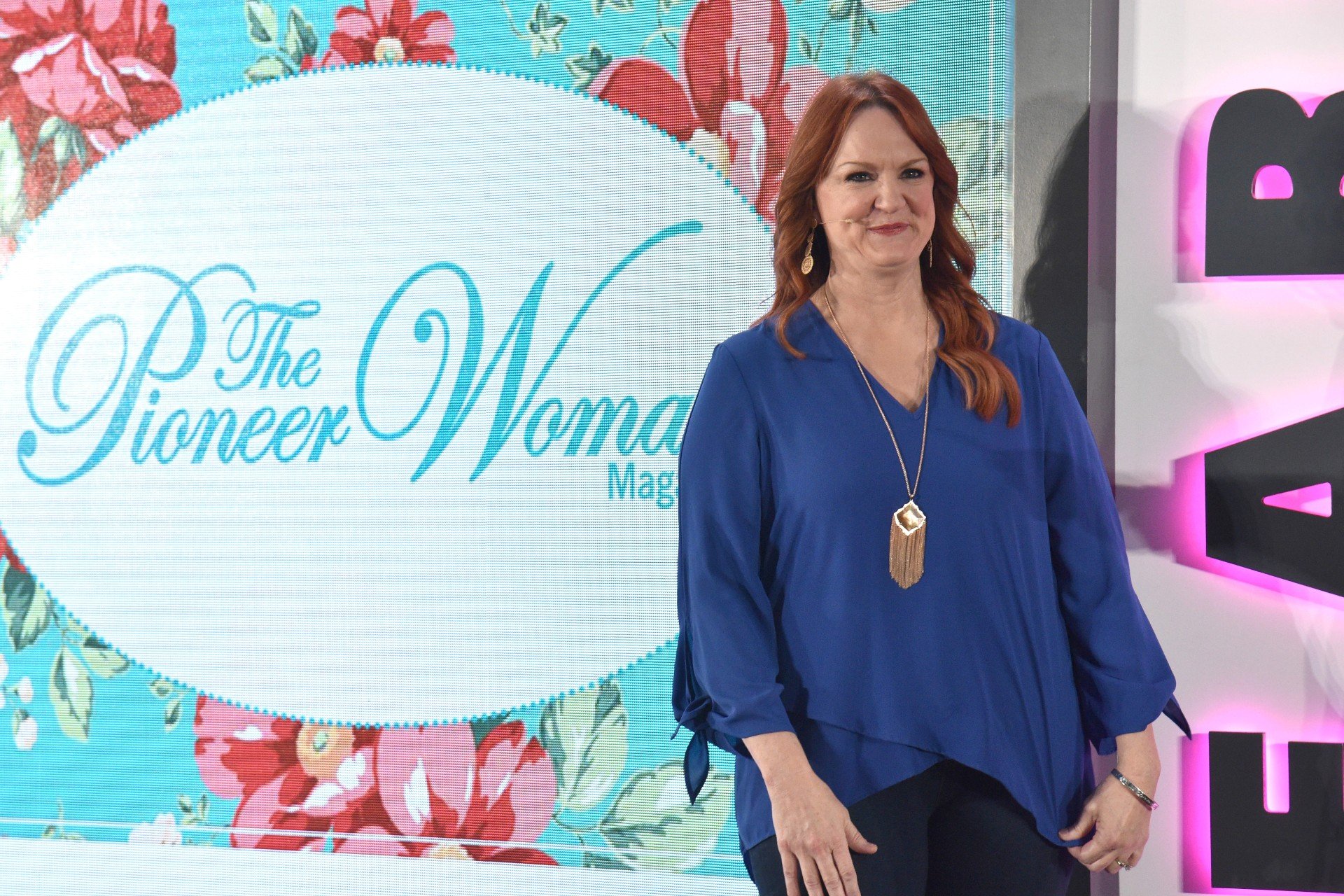 The Pioneer Woman Ree Drummond wears a blue shirt while presenting during a Pioneer Woman event. 