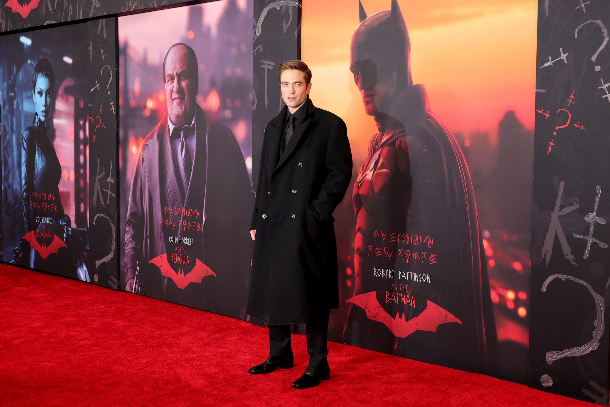Robert Pattinson at the world premiere of 'The Batman' on March 1st in front of a poster for the film with the titular character