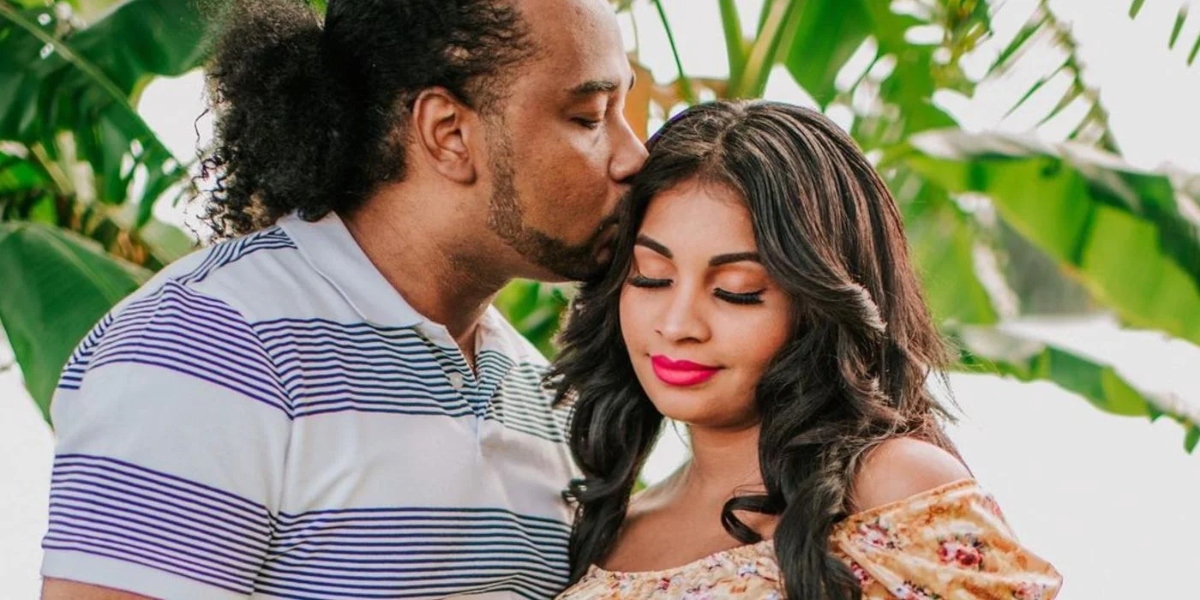 Robert Springs kissing Anny Francisco on the forehead in maternity photos on '90 Day Fiancé'.