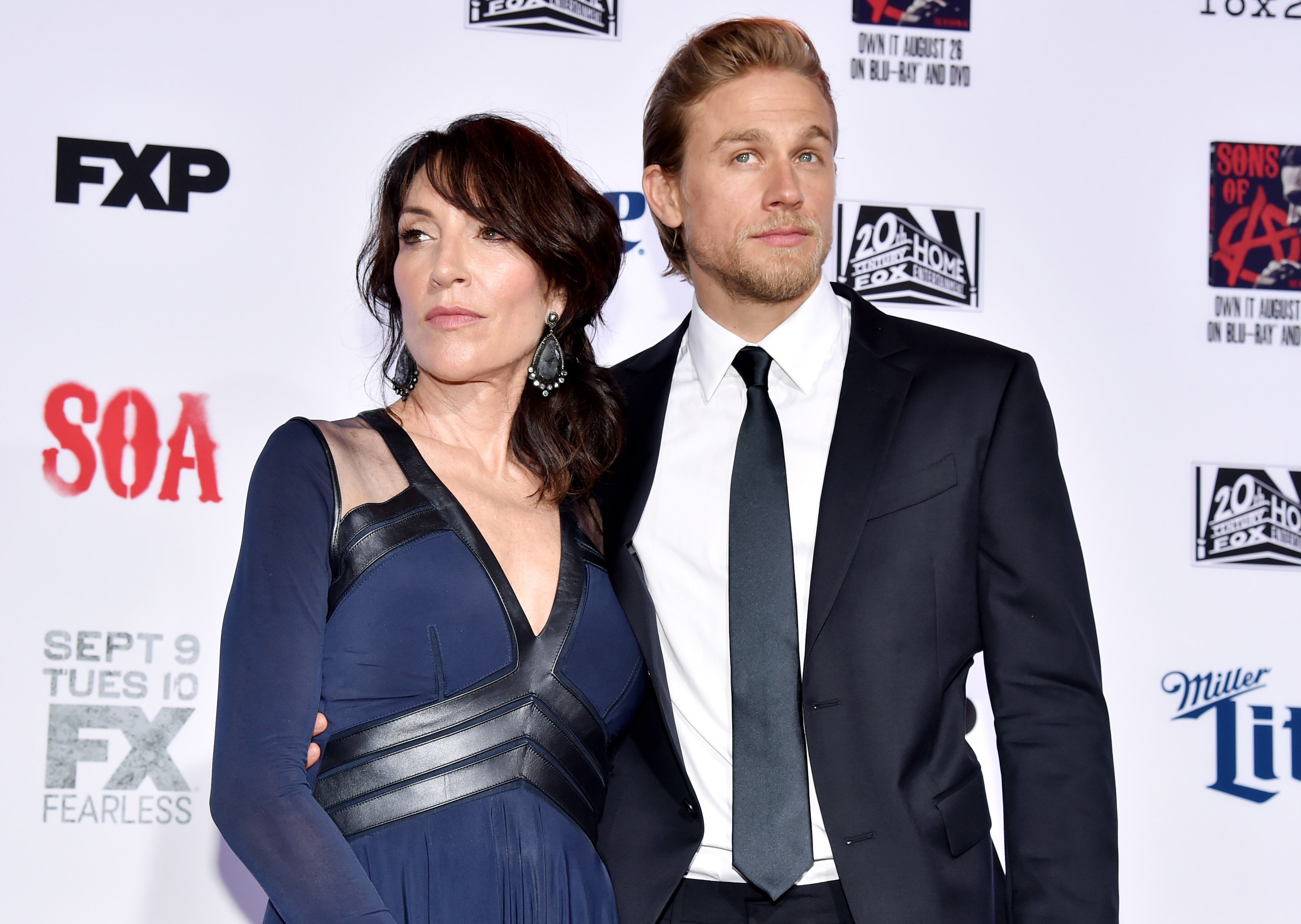 Sons of Anarchy stars Charlie Hunnam and Katey Sagal are honored in some Mayans MC easter eggs. The pair pose for a photo.