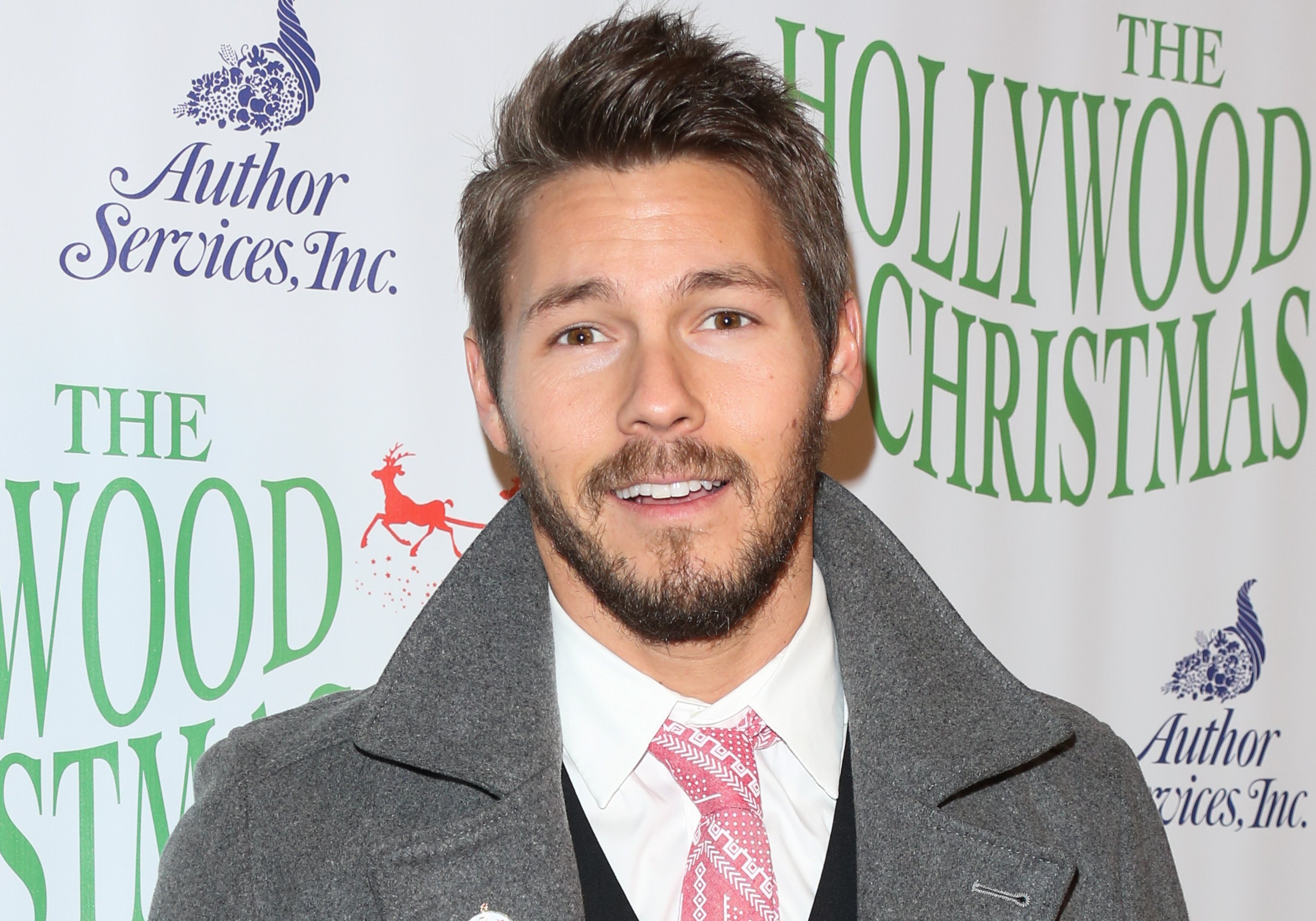 'The Bold and the Beautiful' actor Scott Clifton wearing a suite and grey jacket during a Christmas parade.