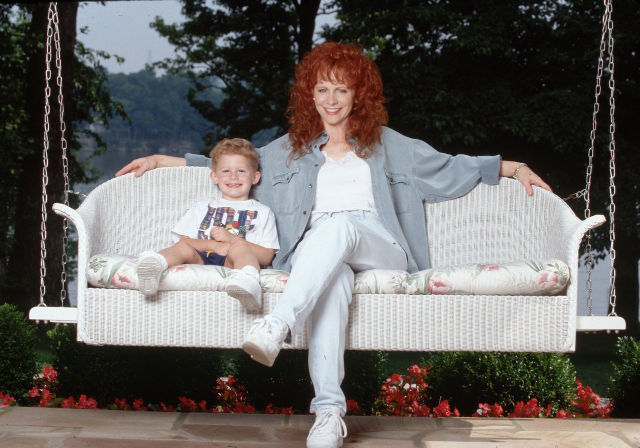 Reba McEntire and her son Shelby relax on a porch swing c. 1994