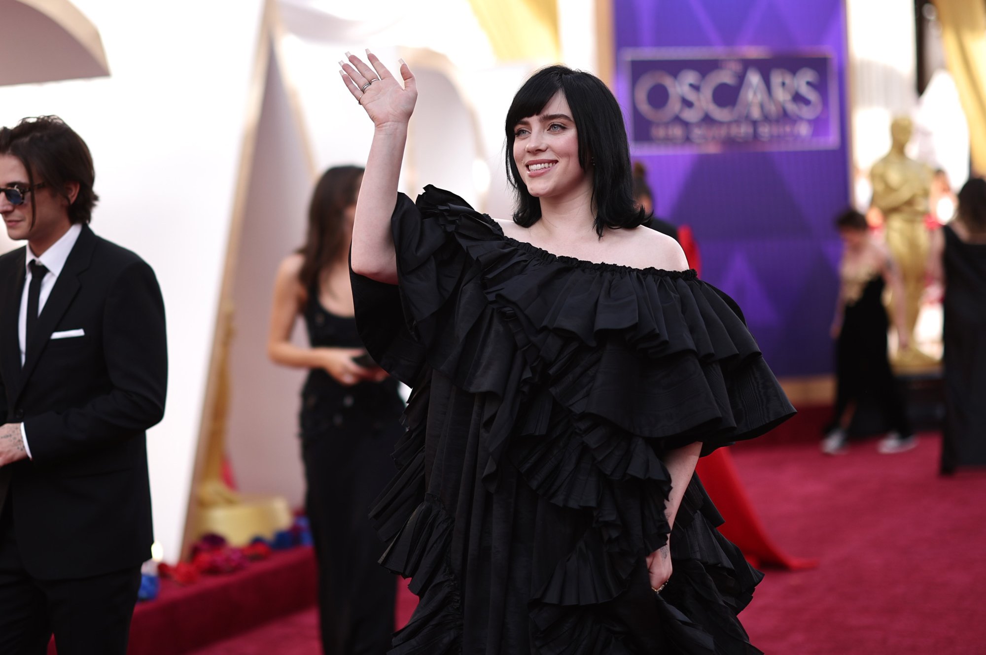 Singer Billie Eilish, who sang the song 'No Time to Die' in the Daniel Craig movie wearing a black dress waving her hand on the Oscars 2022 red carpet