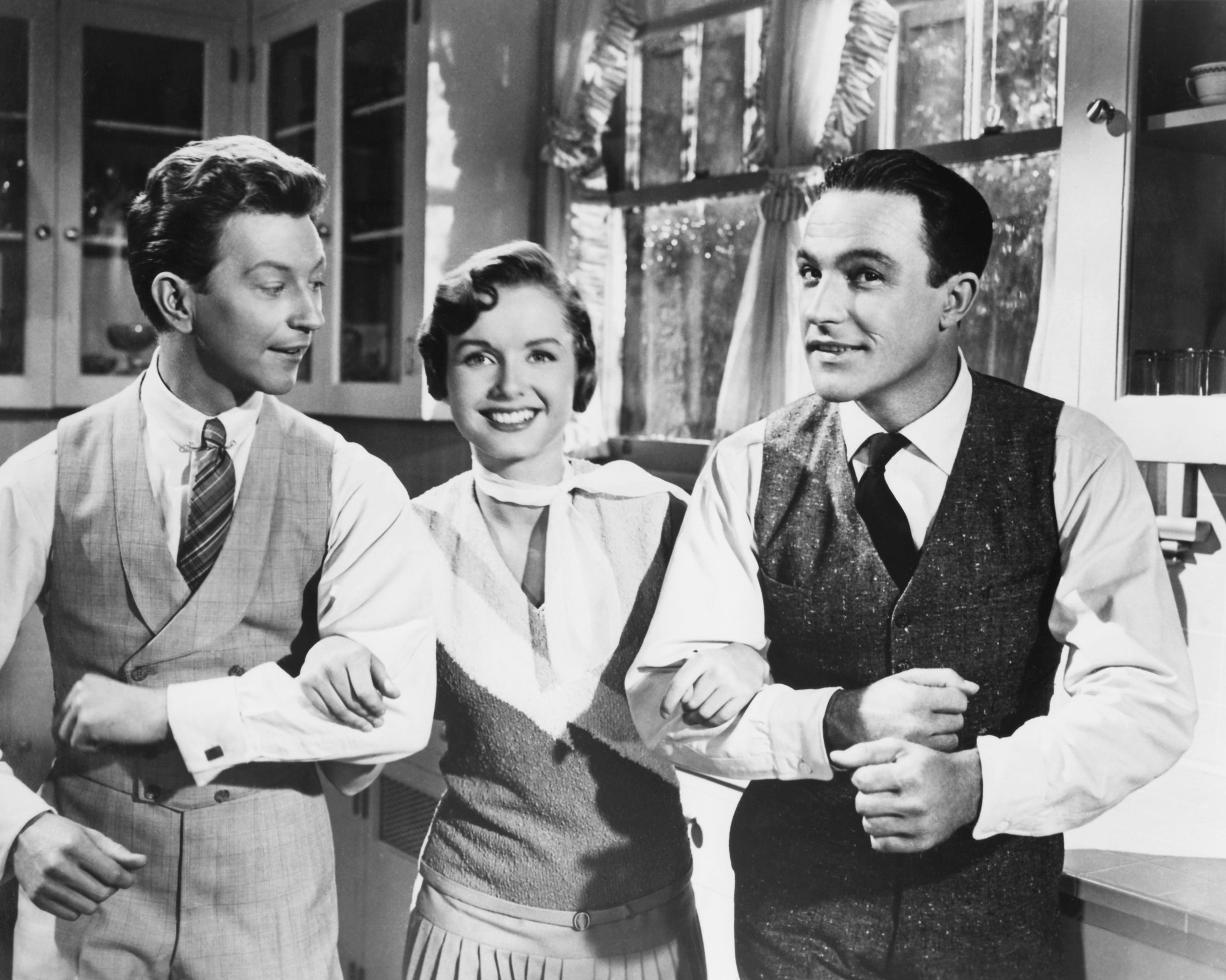 'Singin' in the Rain' Donald O'Connor as Cosmo Brown, Debbie Reynolds as Kathy Selden, and Gene Kelly as Don Lockwood during 'Good Morning' sequence smiling and linking arms