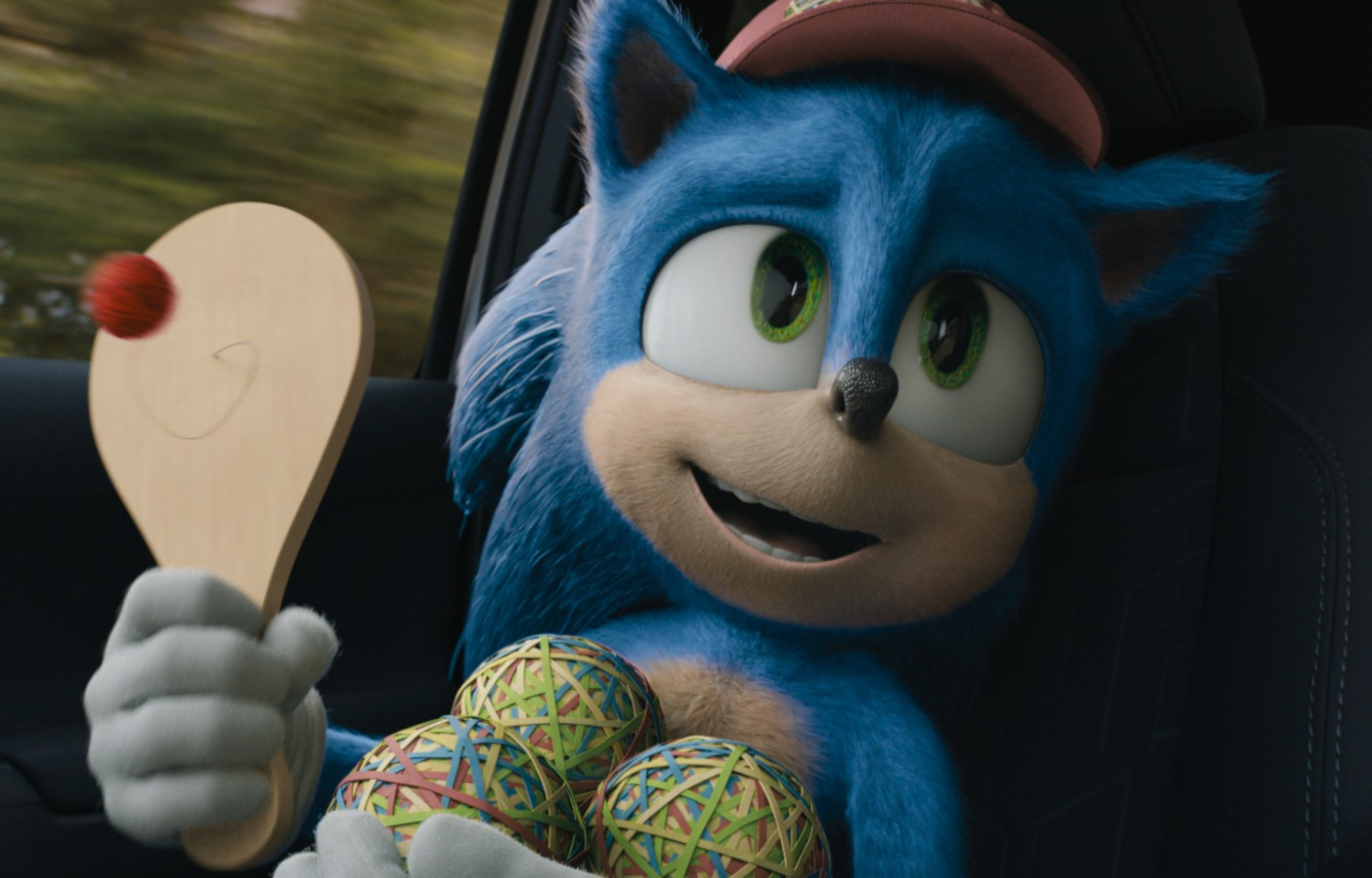 Sonic holding three rubberband balls and a ping-pong toy in 'Sonic the Hedgehog,' which is streaming on Paramount+ and Epix.