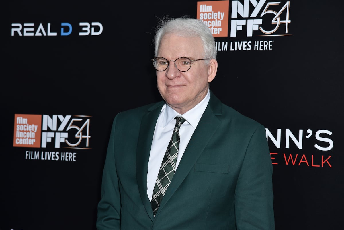 Steve Martin wears a suit and glasses