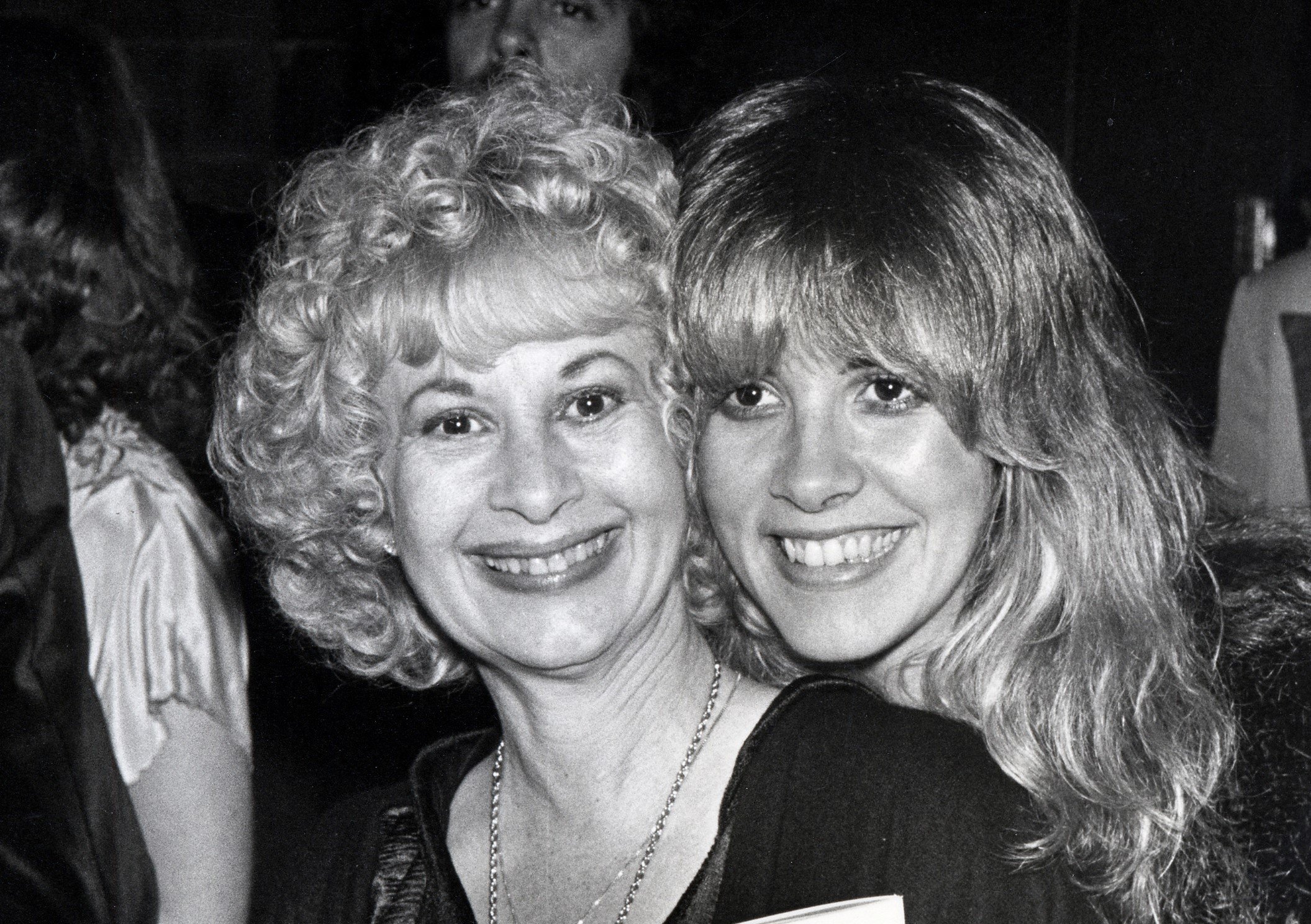 A black and white photo of Stevie Nicks and Barbara Nicks posing cheek to cheek.